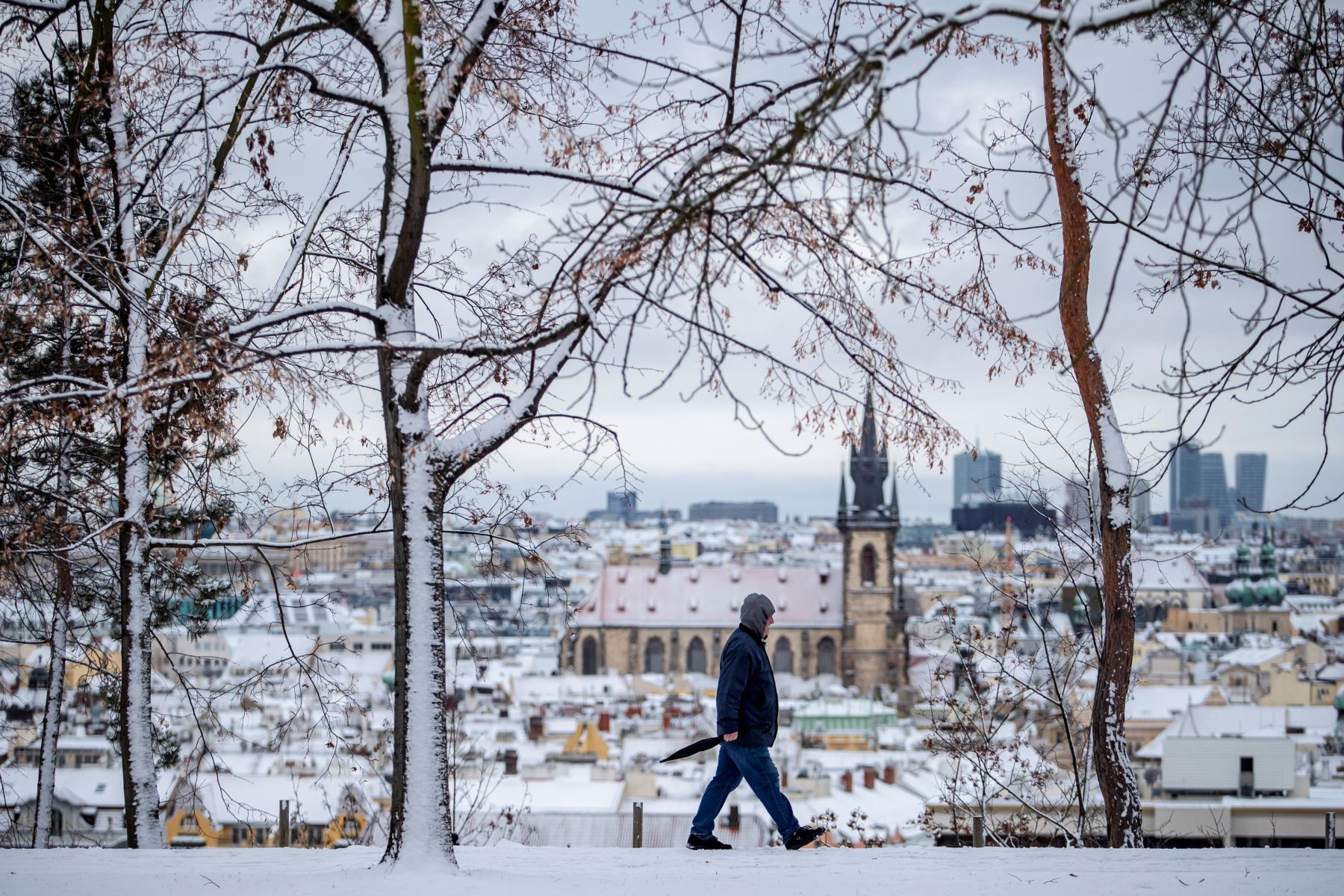 Un hombre camina por un sendero en el que se puede observar el casco viejo de la ciudad que permanece nevado en Praga, República Checa.
Foto: EFE