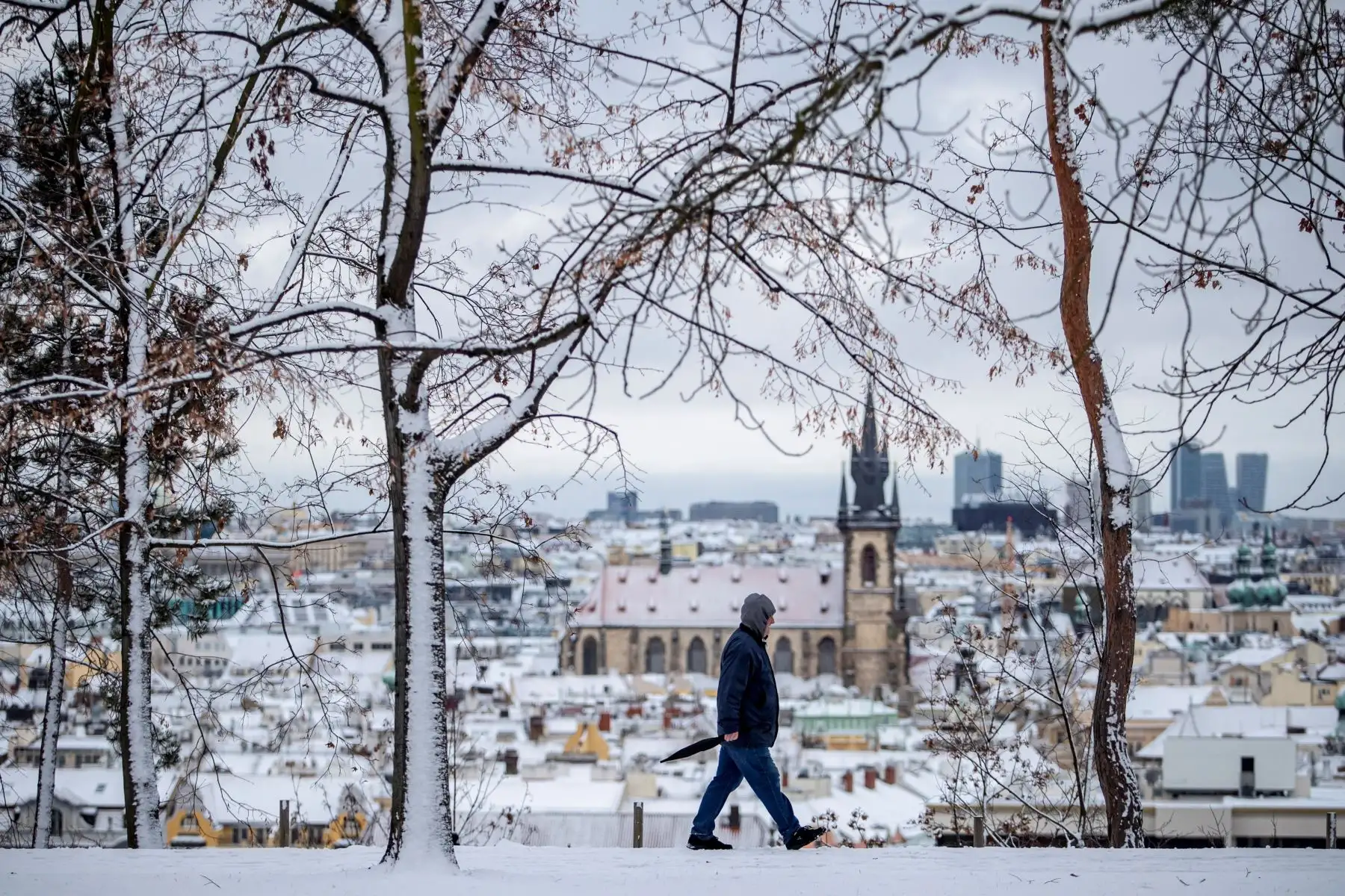 Un hombre camina por un sendero en el que se puede observar el casco viejo de la ciudad que permanece nevado en Praga, República Checa.
Foto: EFE
