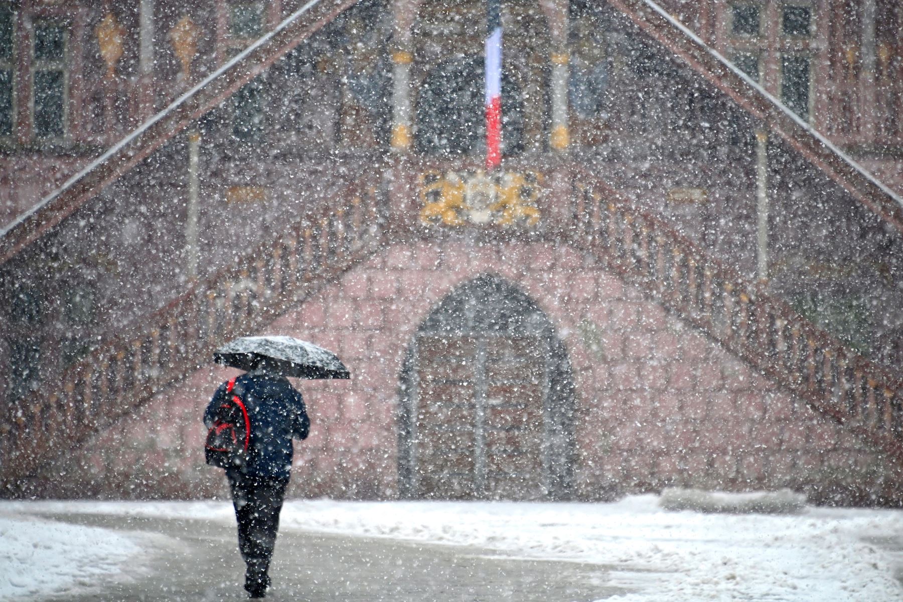 Una mujer camina en una calle de Mulhouse, en el este de Francia,  durante un episodio de nieve en el este de Francia.
Foto: AFP