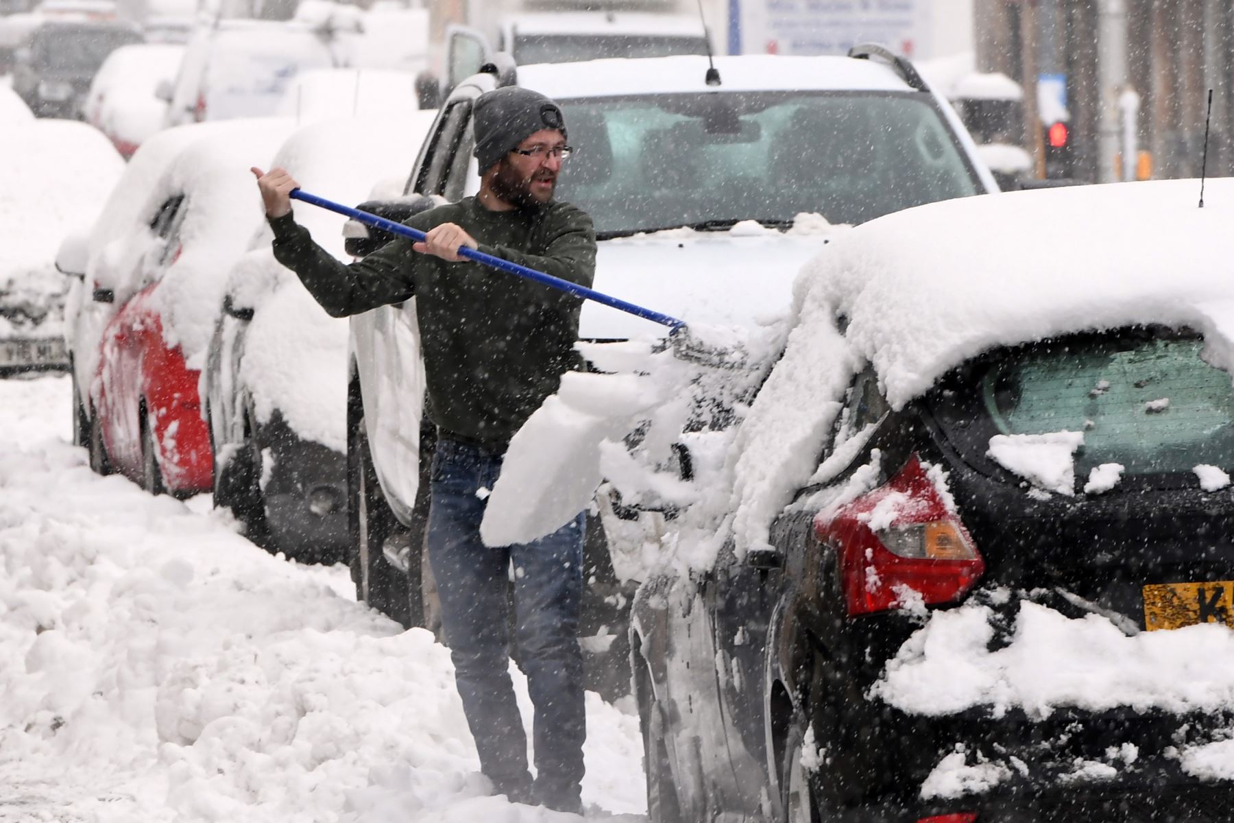 Un hombre limpia la nieve de su automóvil en Auchterarder mientras nevaba intensamente en partes de Escocia.
Foto: AFP