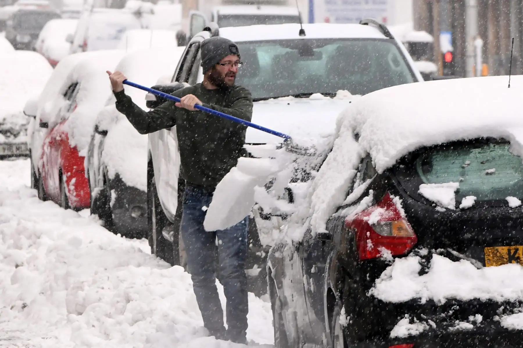Un hombre limpia la nieve de su automóvil en Auchterarder mientras nevaba intensamente en partes de Escocia.
Foto: AFP
