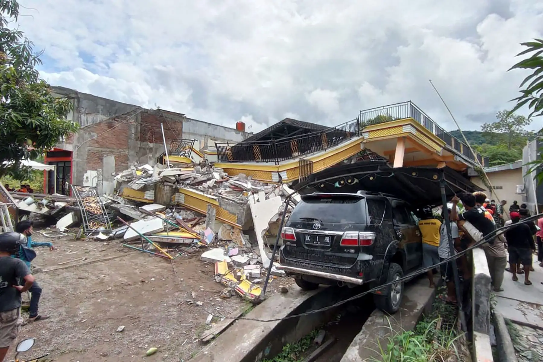 Un automóvil destruido se encuentra entre los escombros al costado de una calle en Mamuju, después de que un terremoto de magnitud 6.2 sacudiera la isla de Sulawesi en Indonesia. Foto: AFP