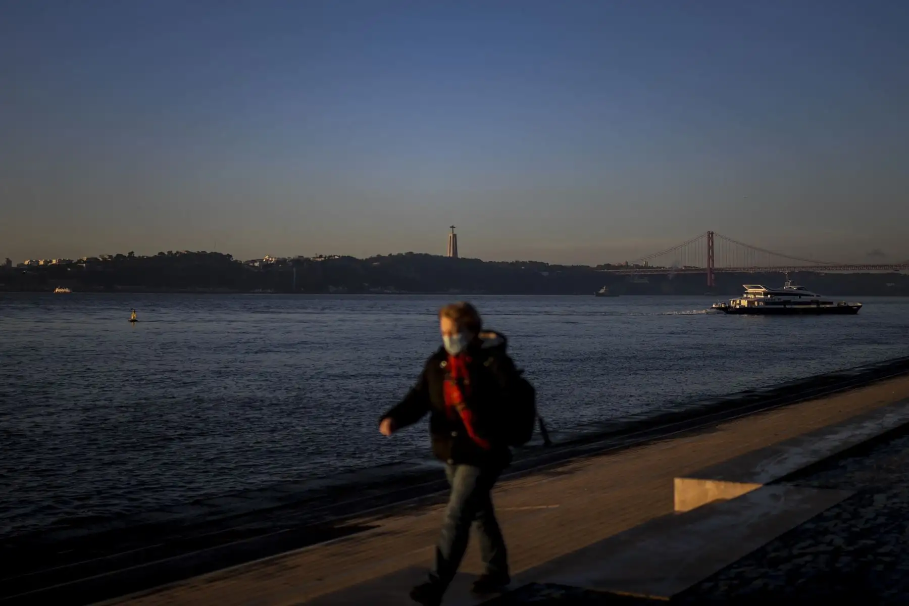 Una mujer que lleva una mascarilla y pasa por Ribeira das Naus en Lisboa Portugal, que  entró en un nuevo bloqueo por un aumento en los casos de coronavirus.Foto: AFP