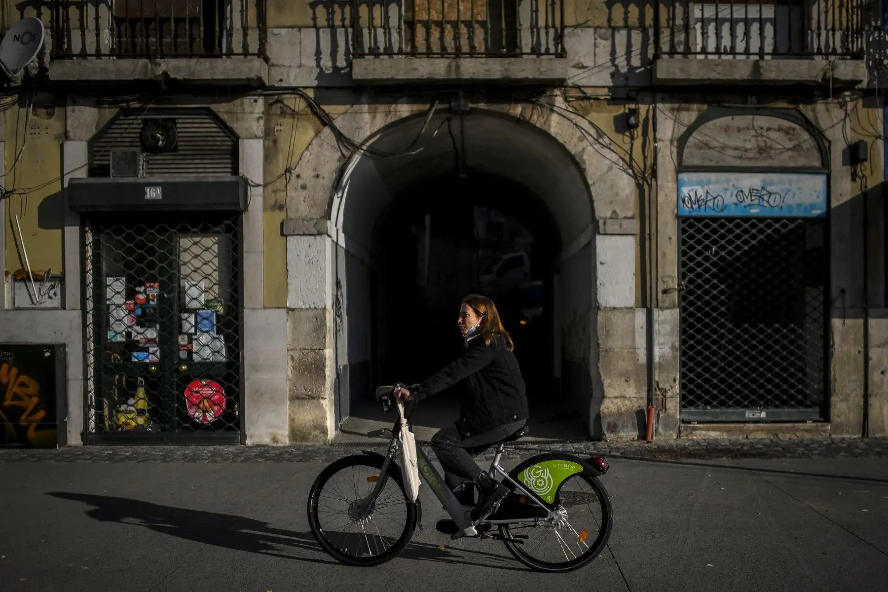 Una mujer pasa en bicicleta frente a tiendas cerradas en Lisboa Portugal, que  entró en un nuevo bloqueo por un aumento en los casos de coronavirus.  Foto: AFP
