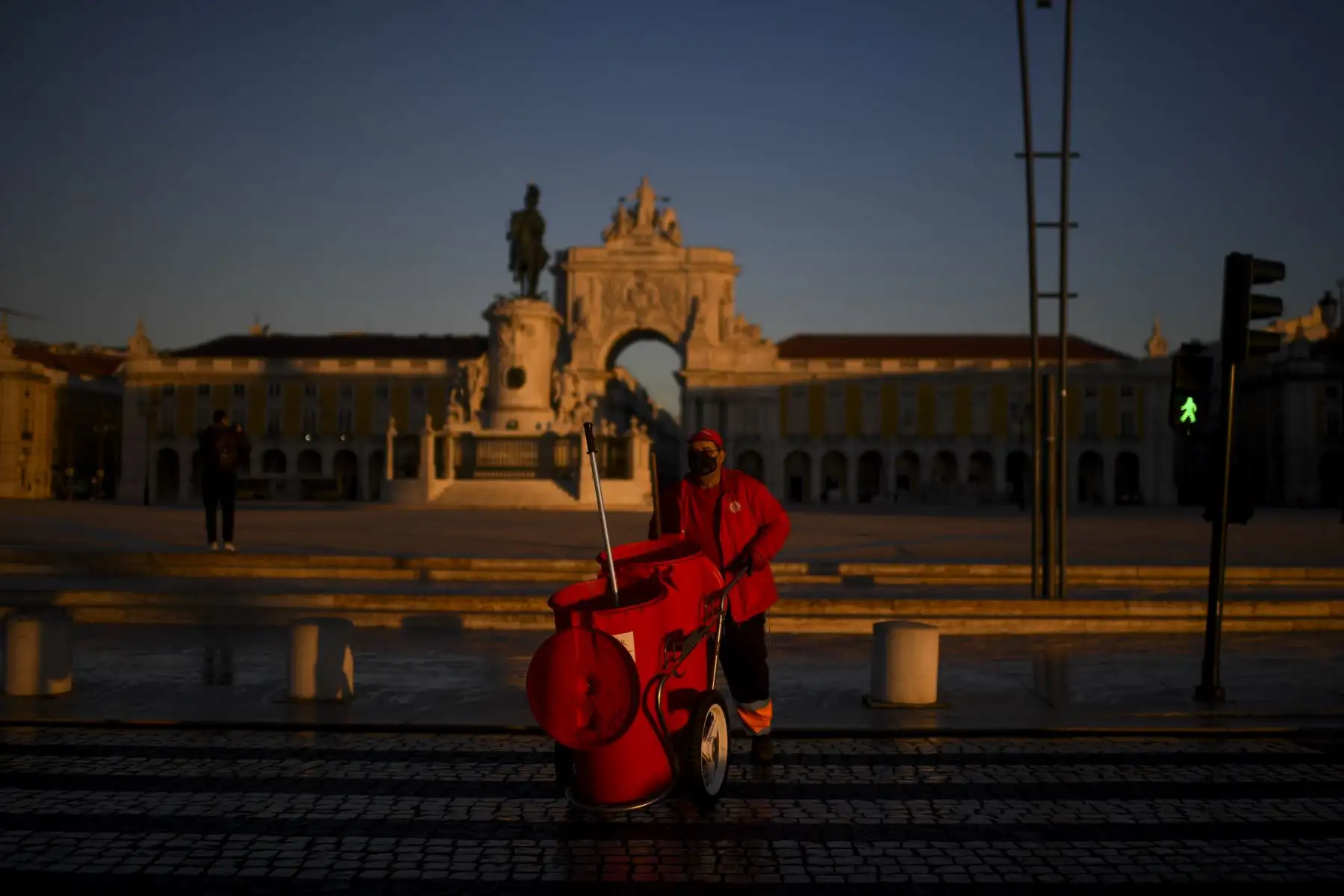 Un trabajador de la ciudad trabaja en la plaza Comercio en Lisboa Portugal, que entró en un nuevo bloqueo por un aumento en los casos de coronavirus. El nuevo coronavirus ha matado al menos a 1.994.833 personas. Foto: AFP
