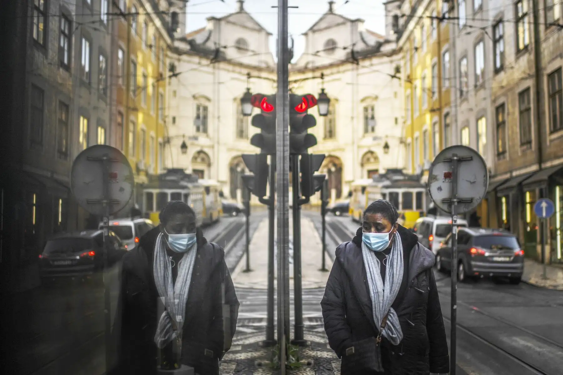 Una mujer que usa una máscara facial se refleja en un escaparate mientras caminaba en Lisboa Portuga, quel ingresó a un nuevo bloqueo por un aumento en los casos de coronavirus. El nuevo coronavirus ha matado al menos a 1.994.833 personas. Foto: AFP