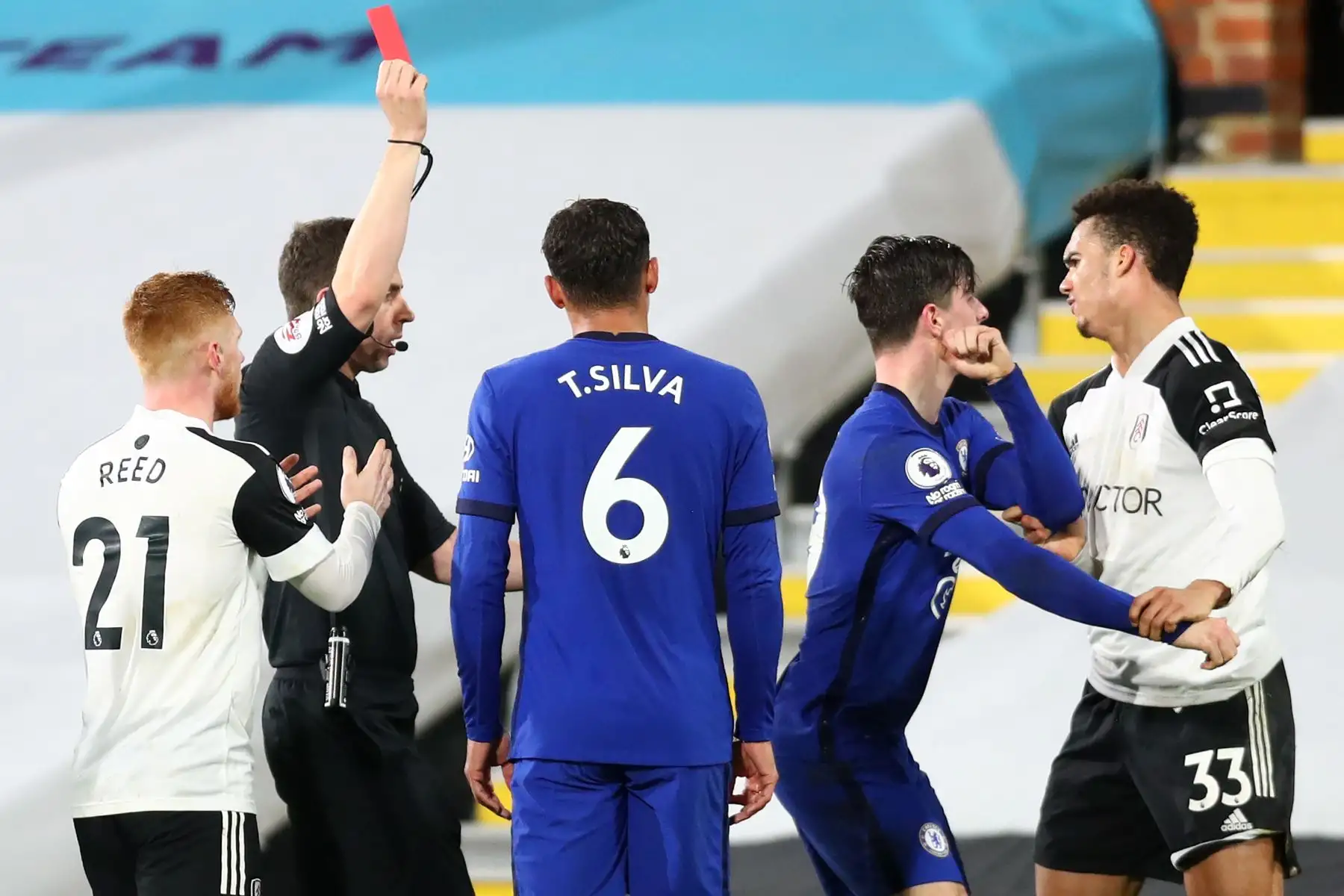 El árbitro Peter Bankes muestra una tarjeta roja al defensor estadounidense de origen inglés del Fulham Antonee Robinson por su entrada al defensor español del Chelsea, César Azpilicueta, durante el partido de fútbol de la Premier League inglesa entre Fulham y Chelsea.