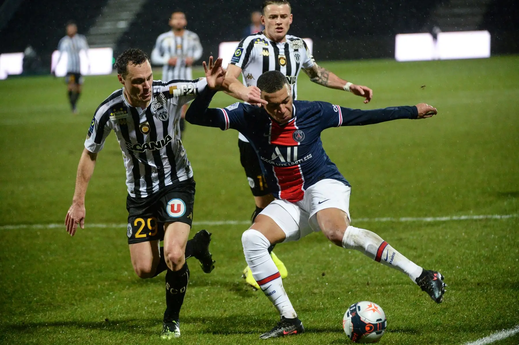 El delantero francés del PSG, Kylian Mbappé compite por el balón con el defensor francés de Angers Vincent Manceau y el centrocampista francés de Angers, Pierrick Capelle, durante el partido de fútbol francés L1 entre Angers y PSG en el Estadio Raymond Kopa en Angers, oeste de Francia. Foto: AFP