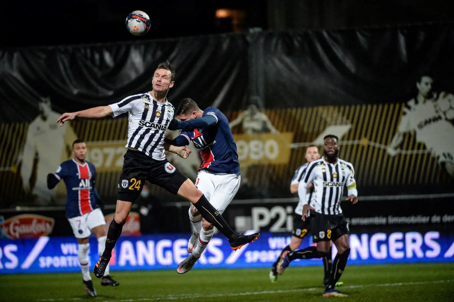 Defensor francés del Angers, Romain Thomas, salta por el balón con el centrocampista español del PSG, Pablo Sarabia, durante el partido de fútbol francés L1 entre Angers y PSG en el Estadio Raymond Kopa en Angers, oeste de Francia. Foto: AFP