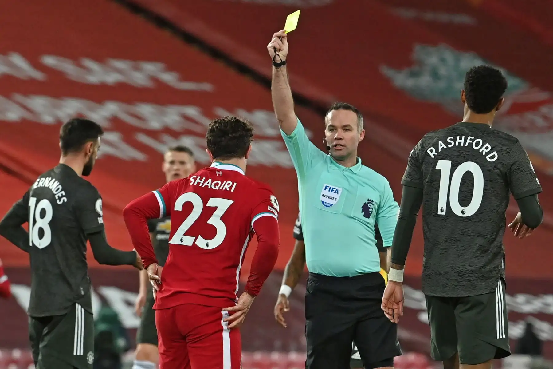 El árbitro inglés Paul Tierney muestra una tarjeta amarilla al centrocampista suizo del Liverpool Xherdan Shaqiri durante el partido de fútbol de la Premier League inglesa entre Liverpool y Manchester United en Anfield en Liverpool.
Foto: AFP