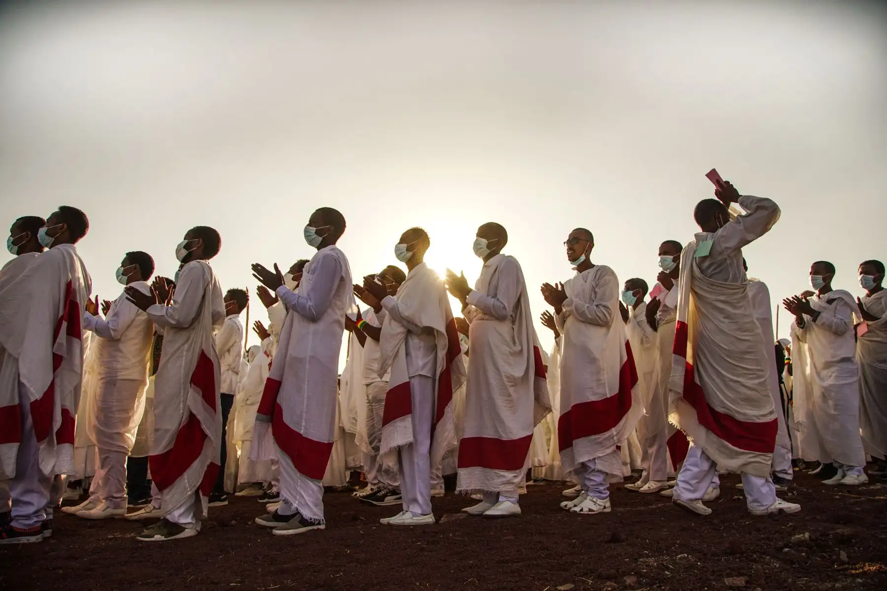 Miembros de la iglesia ortodoxa etíope cantan mientras usan una máscara para protegerse contra el covid-19, durante la celebración de la Epifanía etíope en Addis Abeba, Etiopía que celebran el bautismo de Jesús en el Río Jordan. 
Foto: AFP