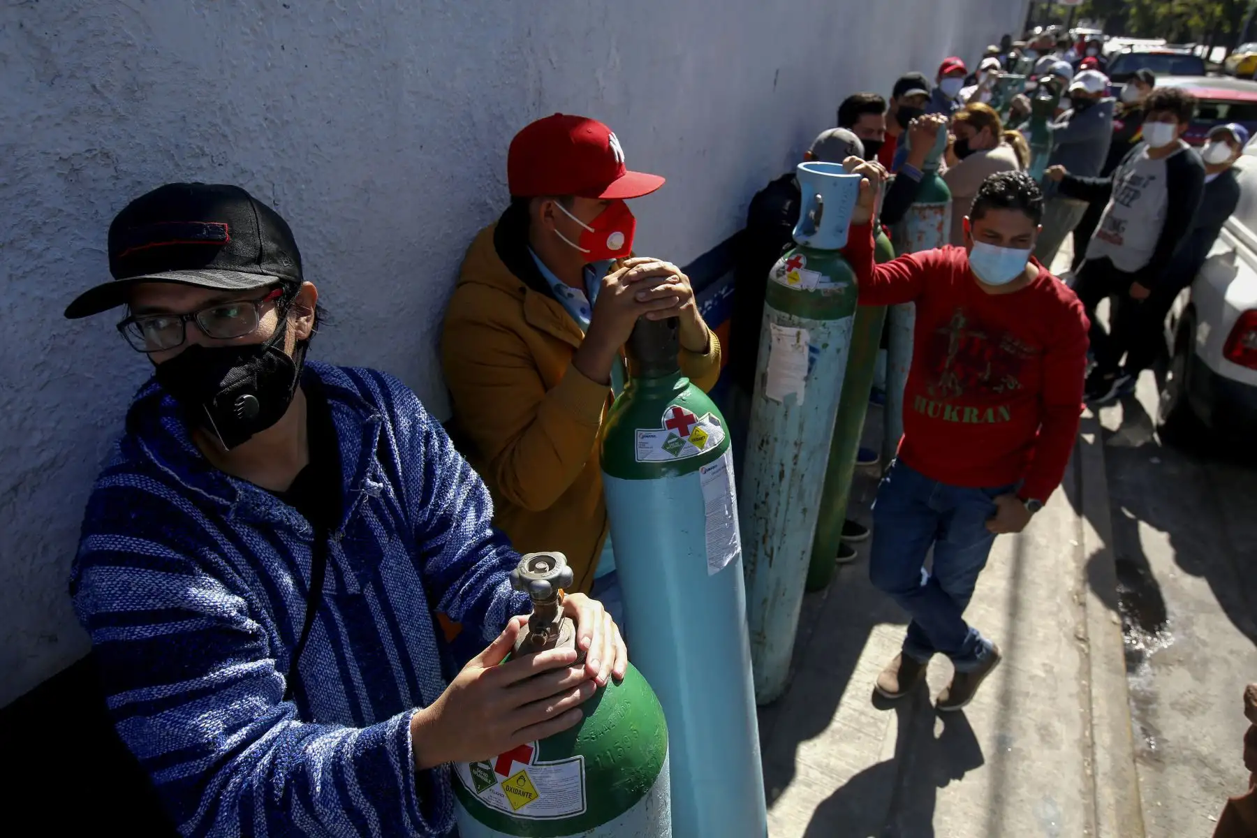 Personas hacen cola para recargar los tanques de oxígeno de sus familiares infectados con covid-19, debido a la escasez de gas medicinal, en Guadalajara Estado de México.
 Foto: AFP