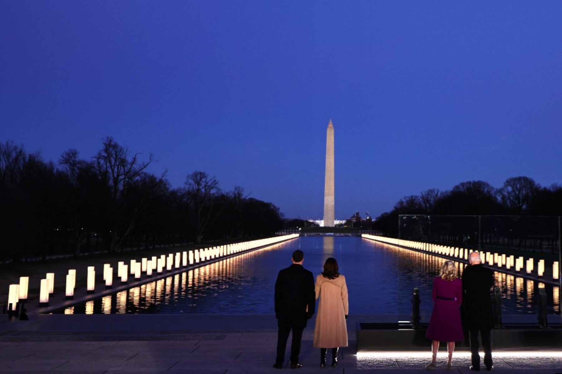 Doug Emhoff, la vicepresidenta electa Kamala Harris, la Dra. Jill Biden y el presidente electo Joe Biden miran al Reflecting Pool mientras observan un momento de silencio en un monumento a las víctimas del coronavirus. Foto: AFP