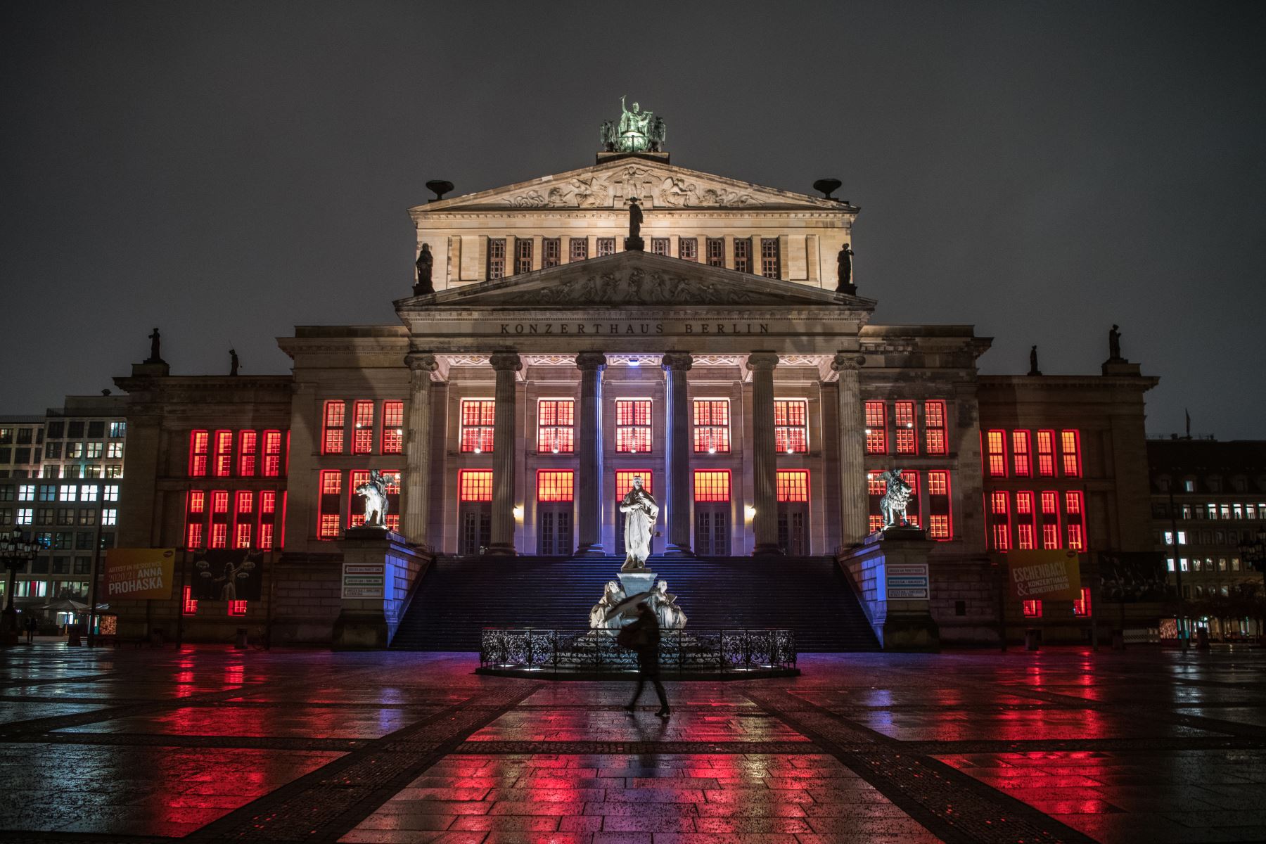 Un peatón solitario pasa frente a la sala de conciertos de Gendarmenmarkt que está iluminada en rojo para llamar la atención sobre la difícil situación de las instituciones culturales en Berlín en medio de la nueva pandemia del coronavirus. Foto: AFP