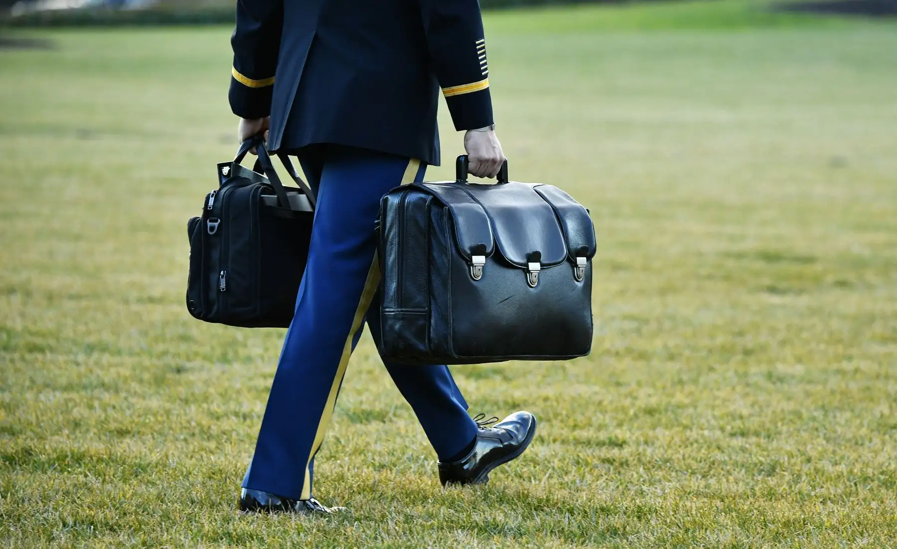 Un ayudante militar lleva la maleta nuclear con el equipo y los códigos nucleares a Marine One después de que el presidente de los Estados Unidos, Donald Trump, y la primera dama Melania bordearan el helicóptero antes de partir del jardín sur de la Casa Blanca en Washington. Foto: AFP