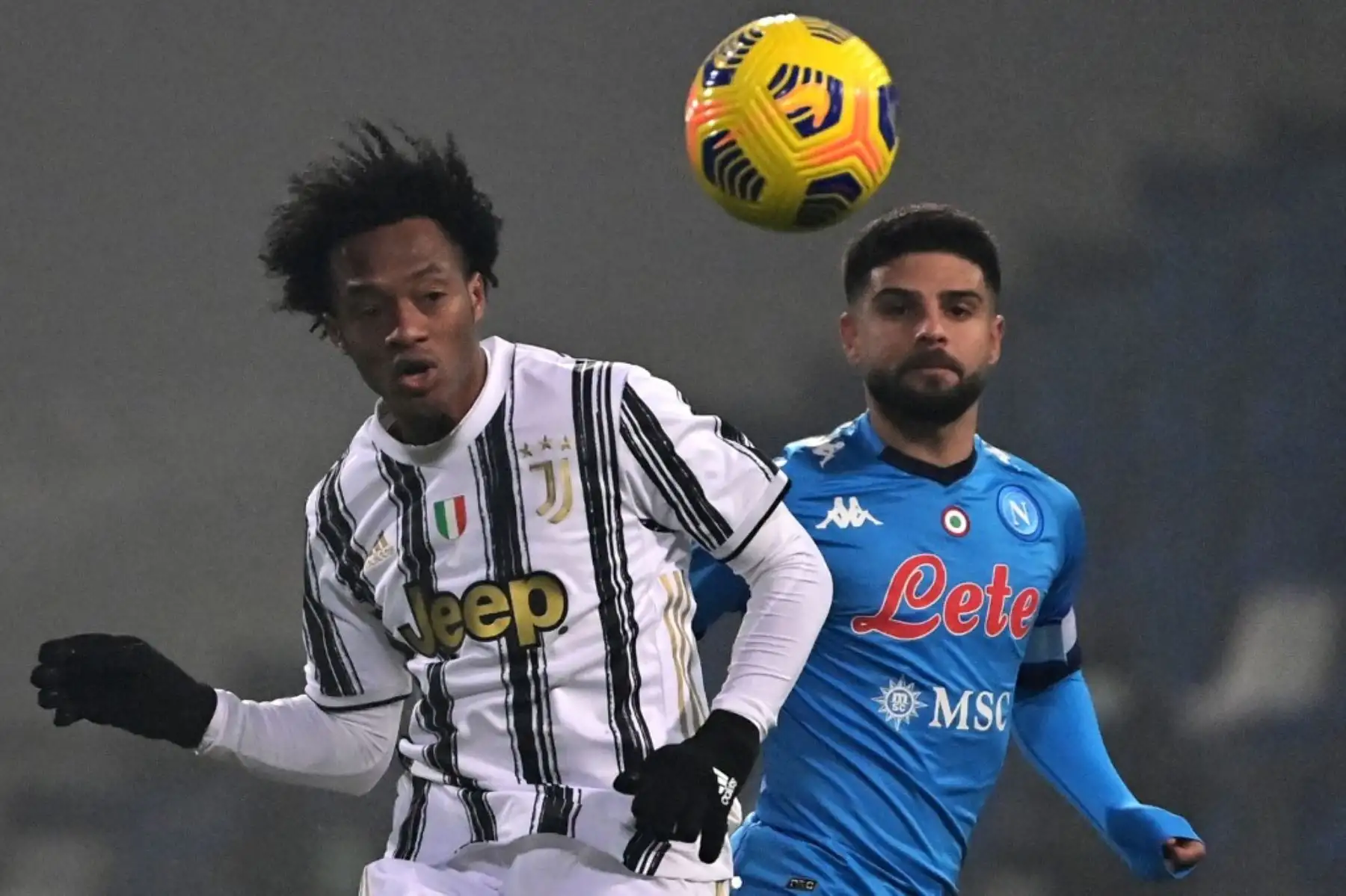 El centrocampista colombiano de la Juventus Juan Cuadrado y el delantero italiano del Napoli Lorenzo Insigne van a por el balón durante el partido de fútbol de la Supercopa italiana entre la Juventus y el Nápoles. Foto: AFP