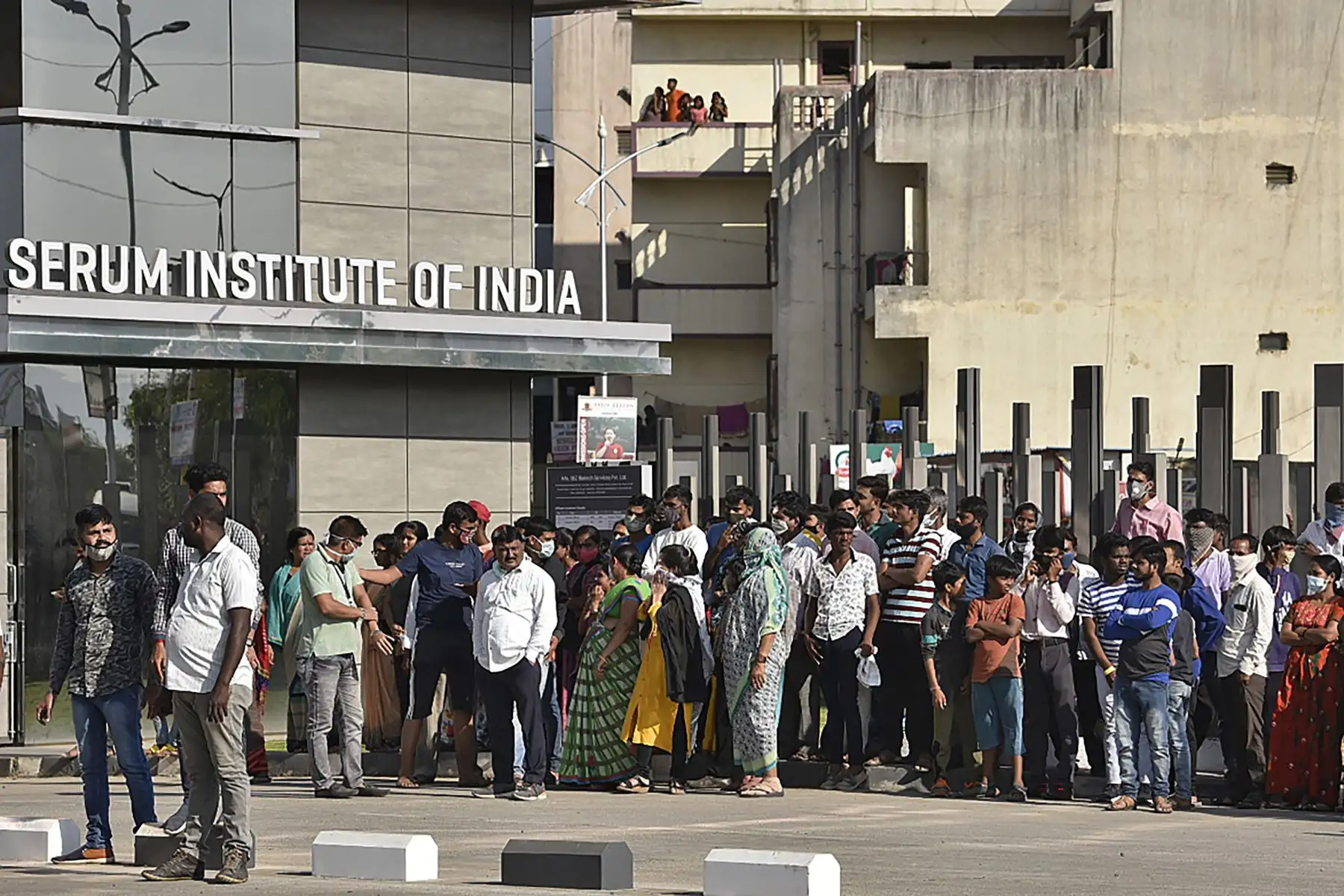La gente se para frente al Instituto del Suero de la India después de que estalló un incendio  en el Instituto del Suero de la India, el mayor fabricante de vacunas del mundo, pero una fuente de la compañía dijo que la producción de medicamentos para prevenir el covid 19 , no fue afectado.
Foto: AFP