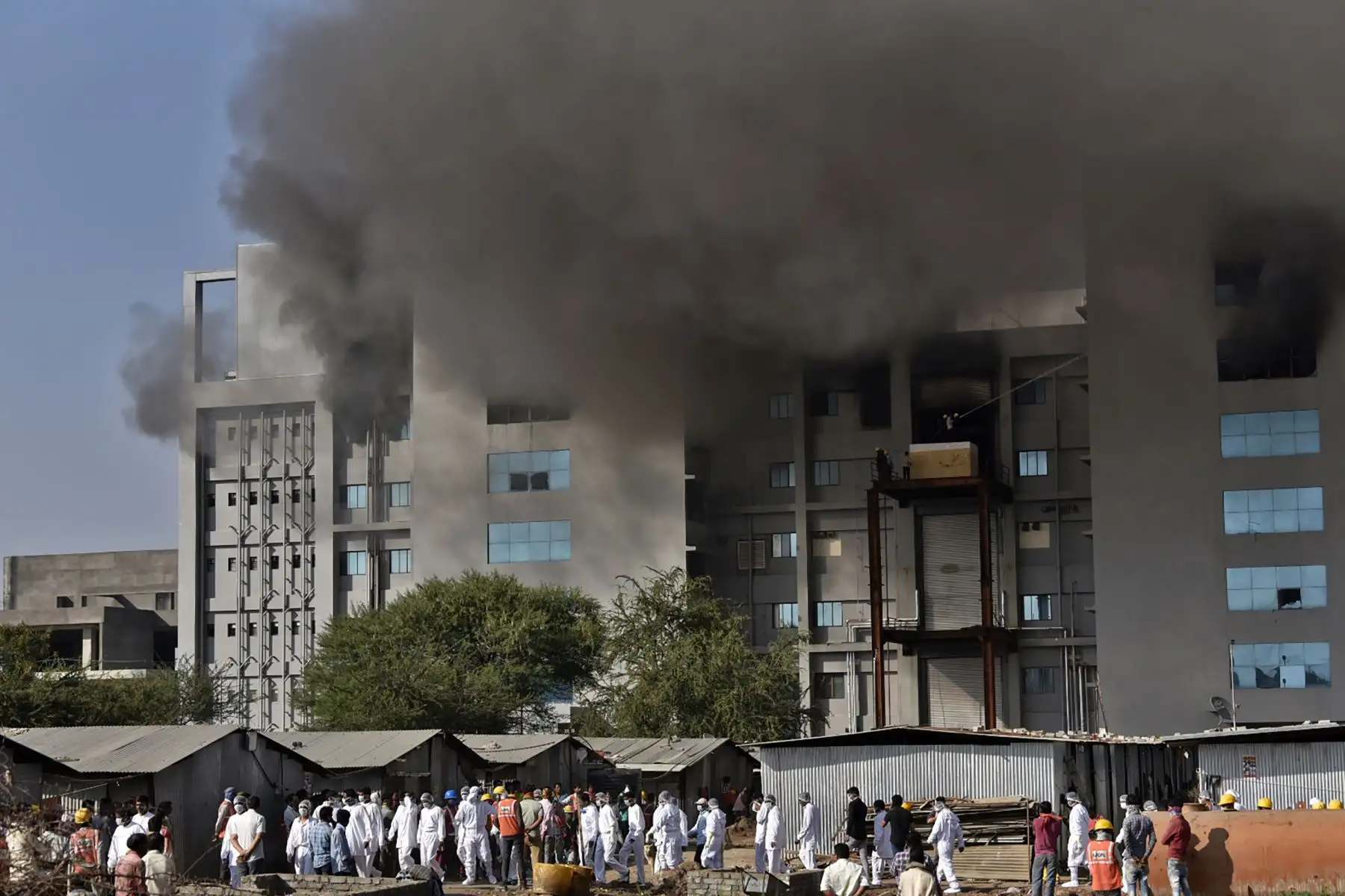 Los trabajadores con equipo de protección caminan después de que estalló un incendio en el Serum Institute de India, el mayor fabricante de vacunas del mundo, pero una fuente de la compañía dijo que la producción de medicamentos para  prevenir el coronavirus Covid-19 no se vio afectado.
Foto: AFP