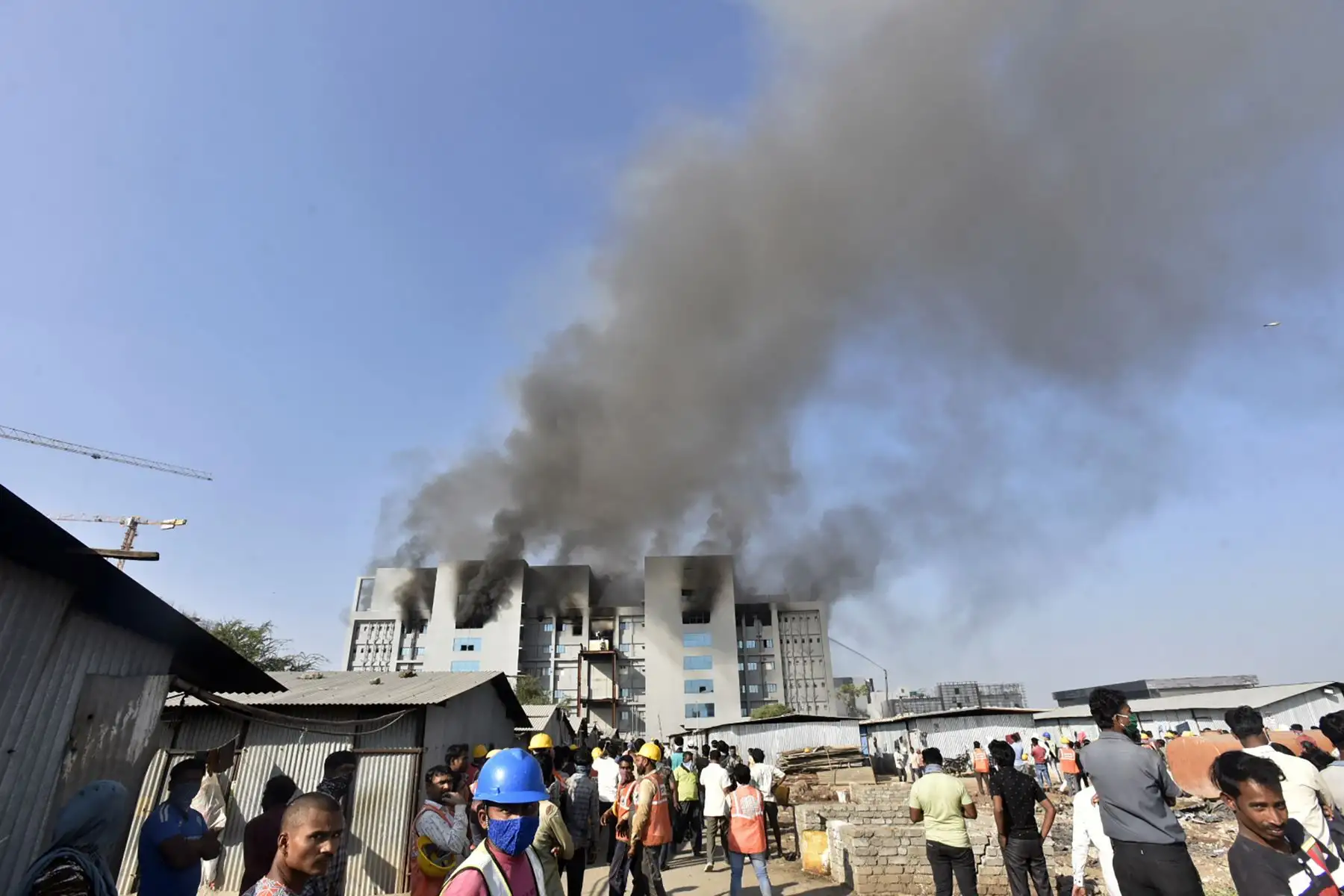 La gente observa cómo se eleva el humo después de que estalló un incendio en el Serum Institute de India, el mayor fabricante mundial de vacunas, pero una fuente de la compañía dijo que las vacunas para  prevenir el coronavirus covid-19 no se vio afectado.
Foto: AFP