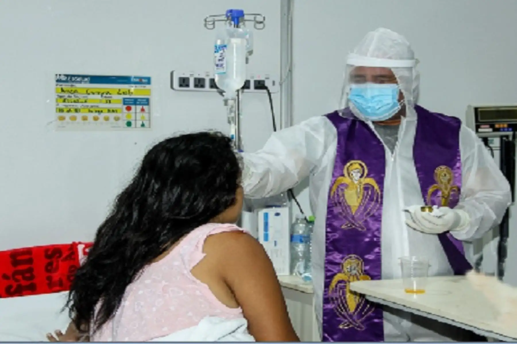 Vestido con un mameluco blanco, con la estola morada en el cuello y protegido con guantes, mascarilla y careta facial, el padre Juan Arturo García Trelles, oró por cada uno de los pacientes de la villa y los ungió en la frente para darles el sacramento y la bendición católica.