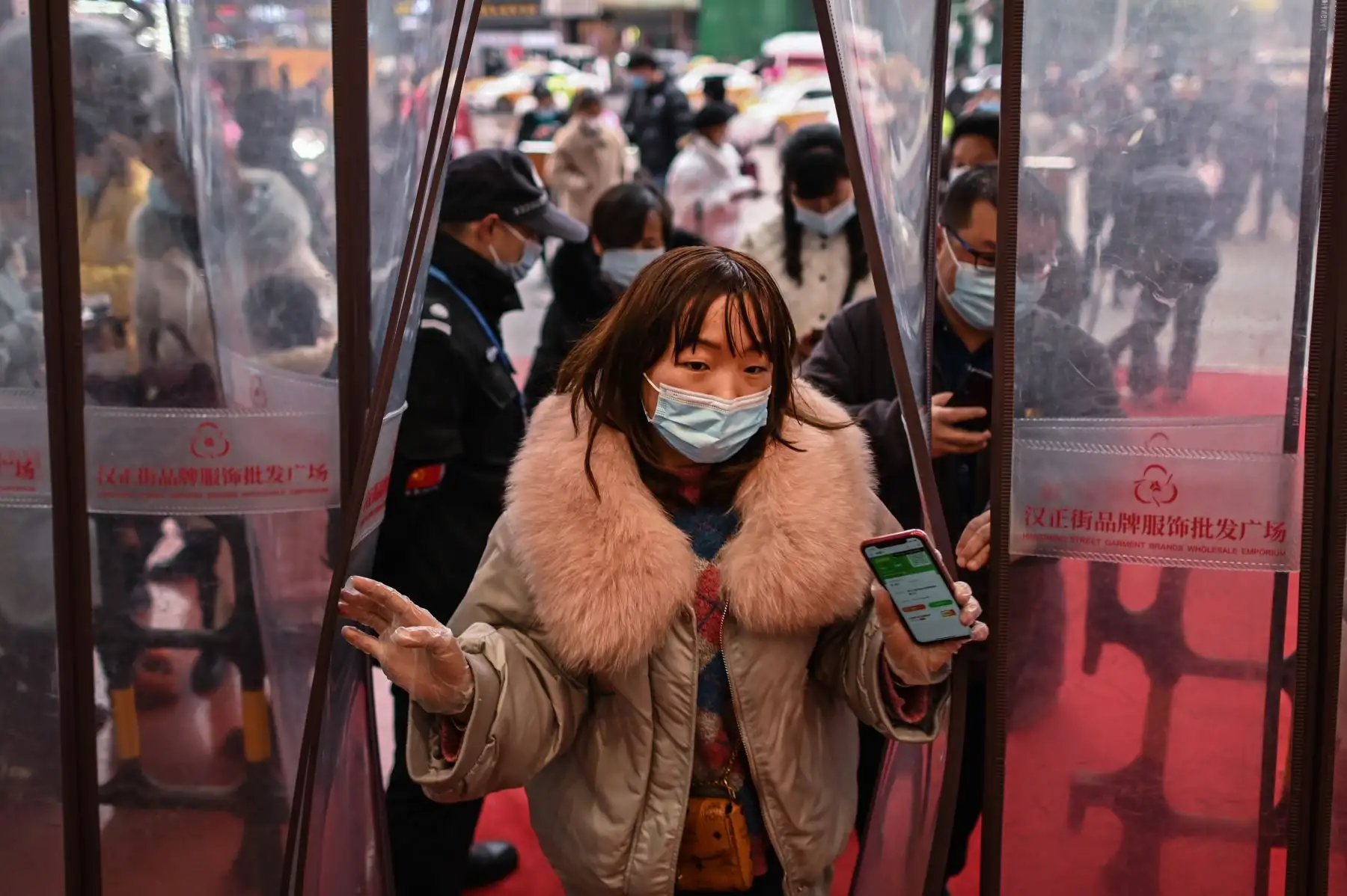 Una mujer que usa una mascarilla como medida preventiva contra el coronavirus Covid-19 ingresa a un centro comercial luego de mostrar su código de salud en Wuhan. Foto: AFP