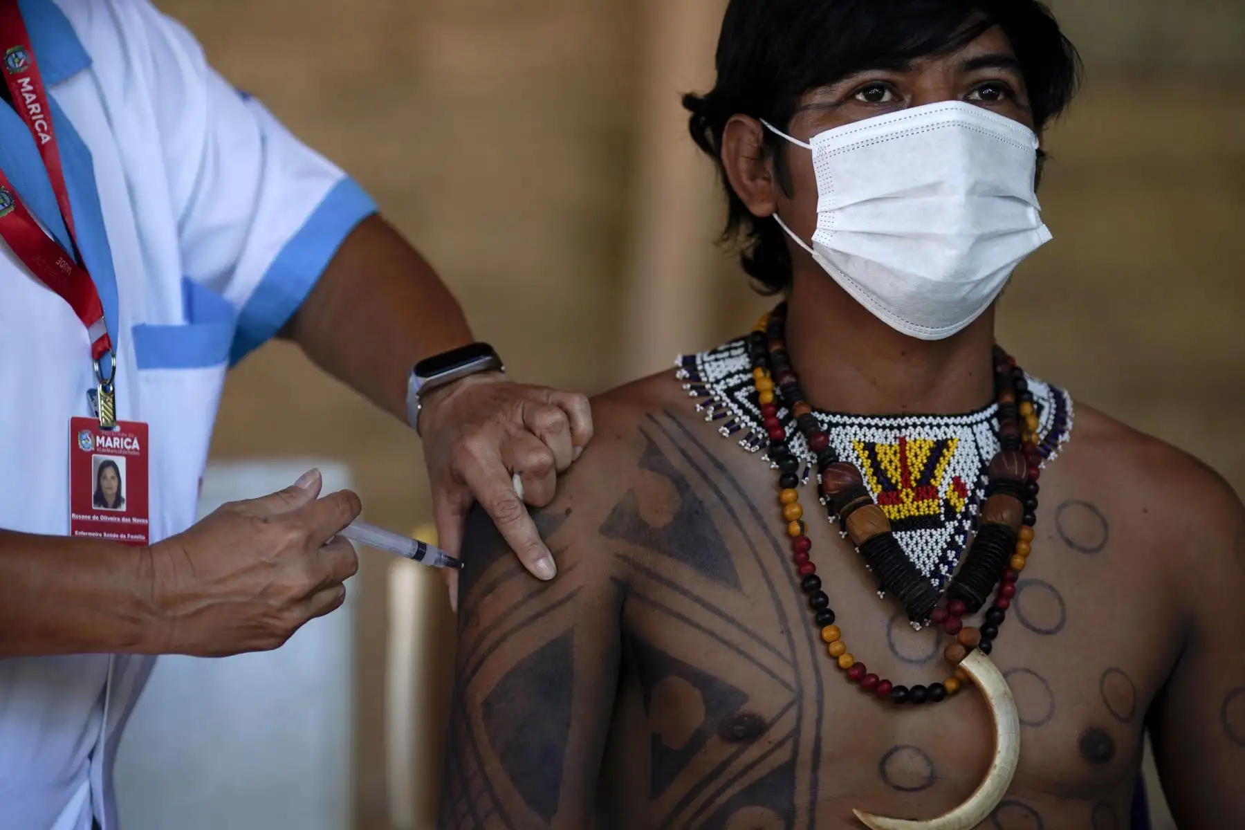 Un indígena guaraní es inoculado con la vacuna CoronaVac de Sinovac Biotech contra covid-19 en el campamento de la tribu Sao Mata Verde Bonita, en tierra indígena guaraní, en la ciudad de Marica, estado de Río de Janeiro, Brasil.
Foto : AFP