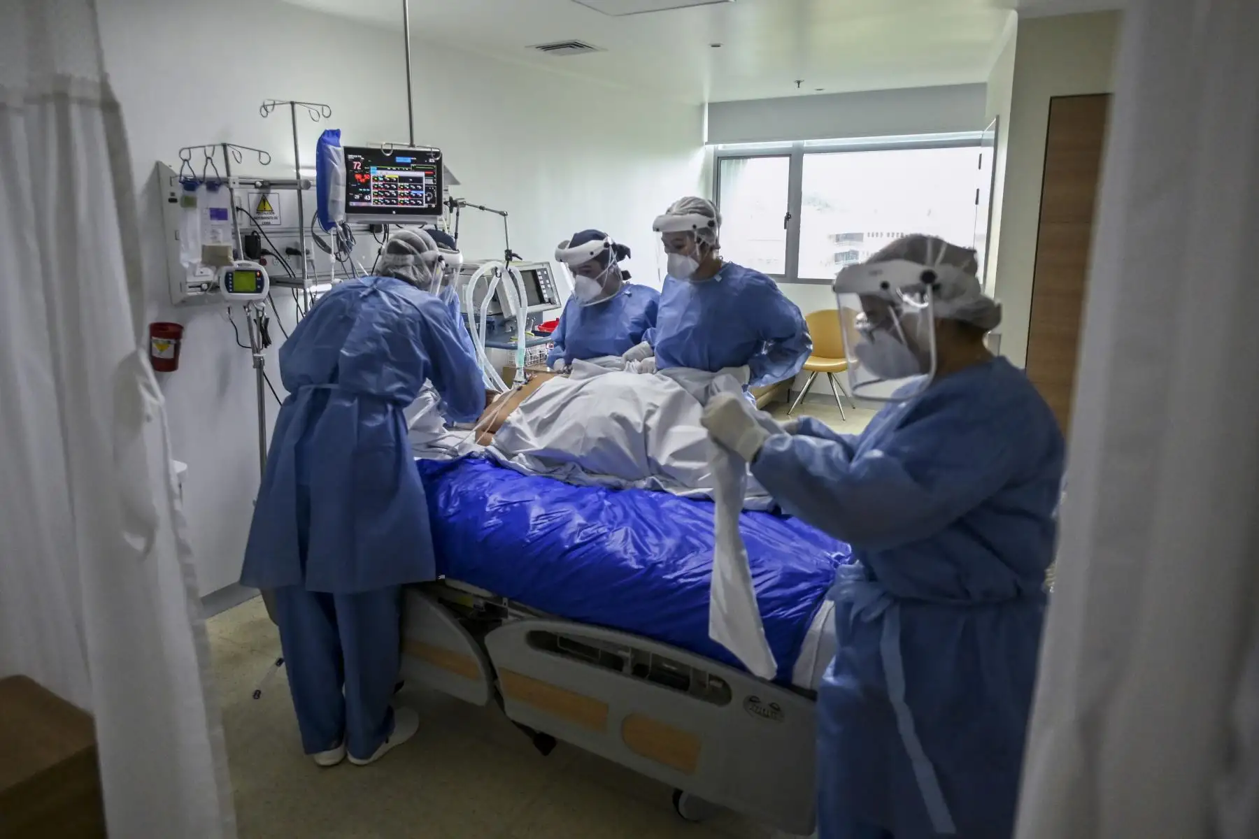 Trabajadores de salud revisan a un paciente de covid -19 en la Unidad de Cuidados Intensivos (UCI) del Hospital Pablo Tobón Uribe, en Medellín.
Foto: AFP