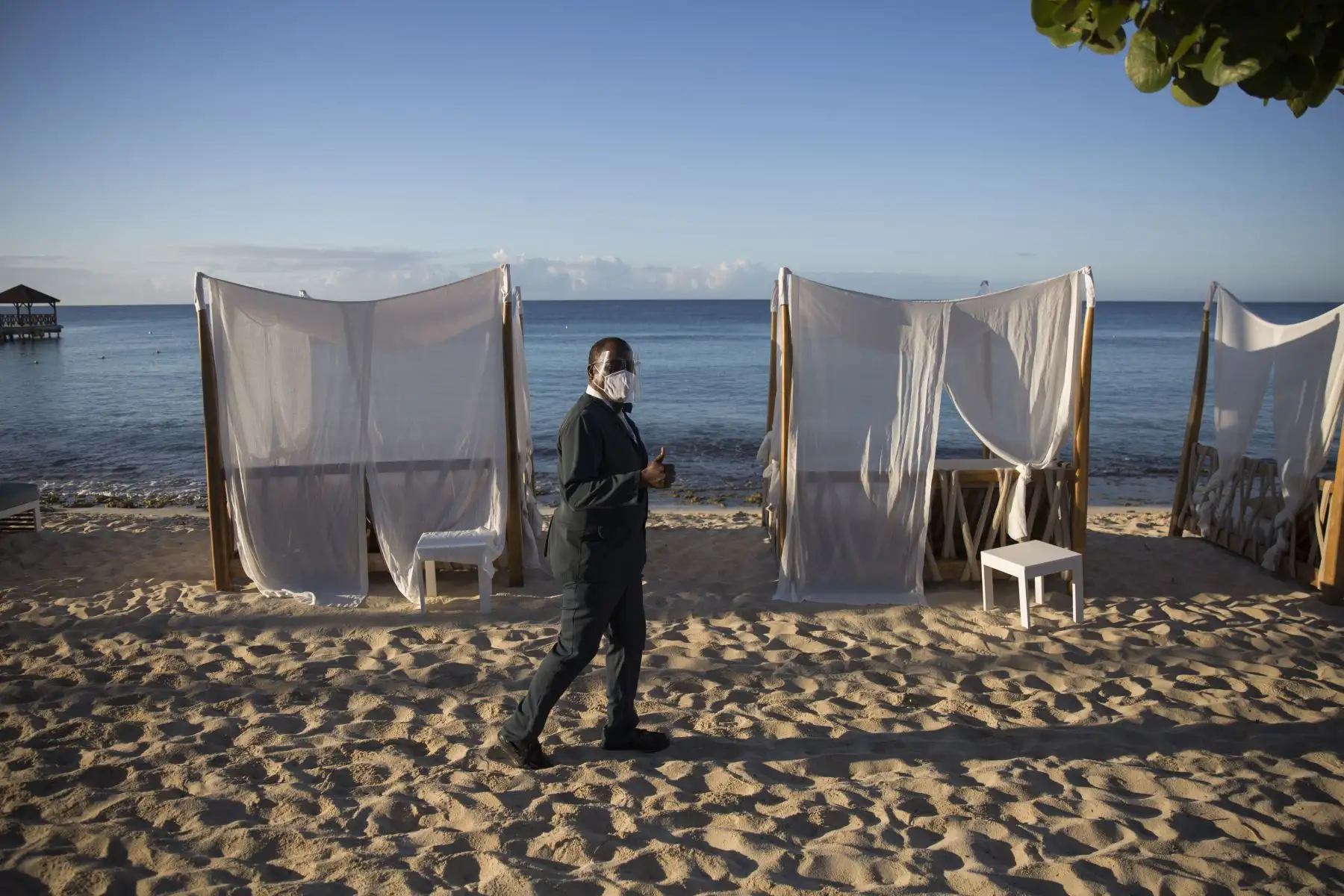 Un empleado de un hotel todo incluido que usa una mascarilla como medida de protección contra la propagación del Covid-19, levanta el pulgar luego de su reapertura en Bayahibe, provincia de La Altagracia, este de República Dominicana.
Foto: AFP
