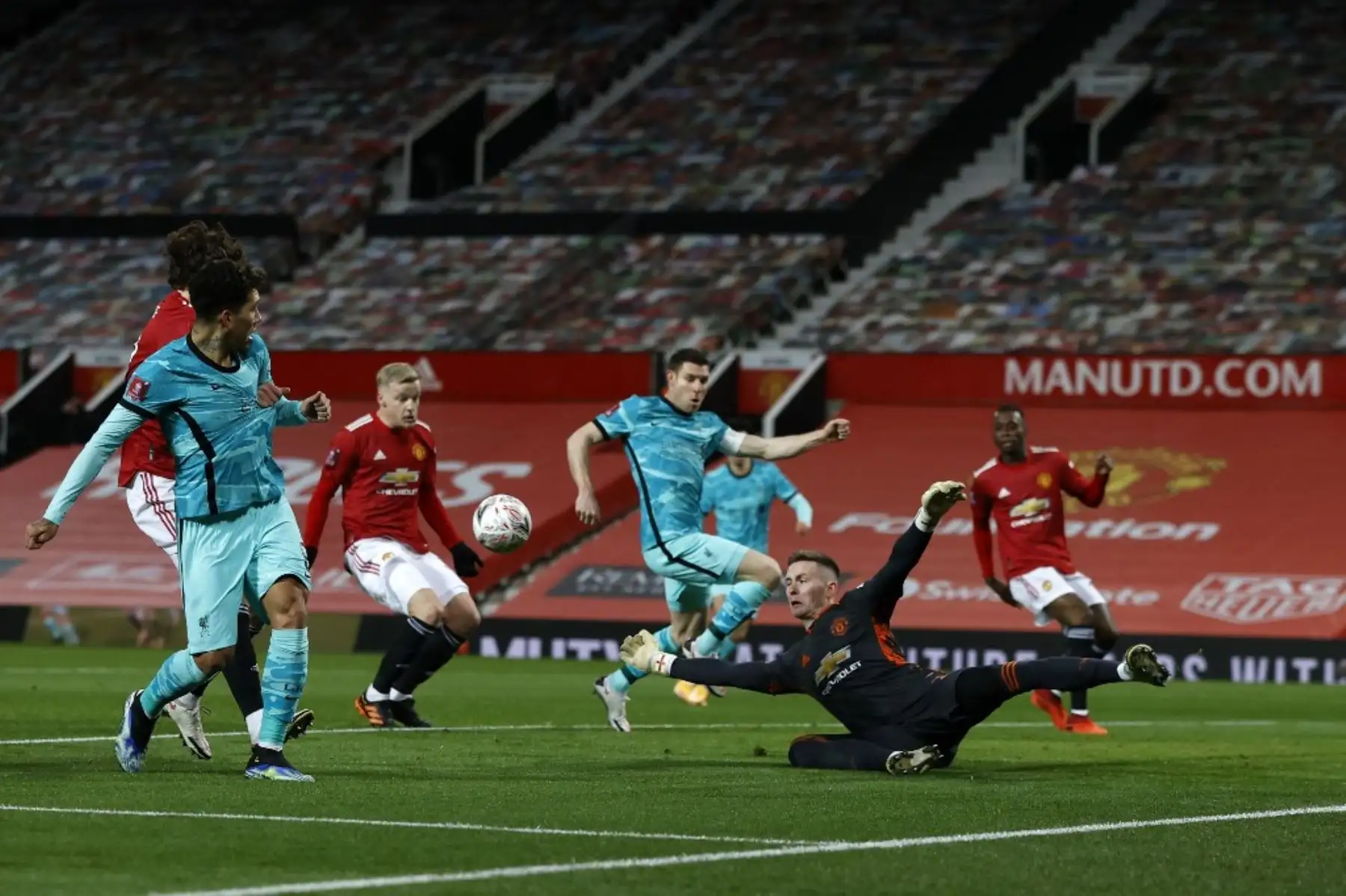 El portero inglés del Manchester United Dean Henderson (2a desde la derecha) se zambulle para bloquear el balón durante el partido de fútbol de cuarta ronda de la Copa FA inglesa entre Manchester United y Liverpool en Old Trafford en Manchester, noroeste de Inglaterra. Foto: AFP