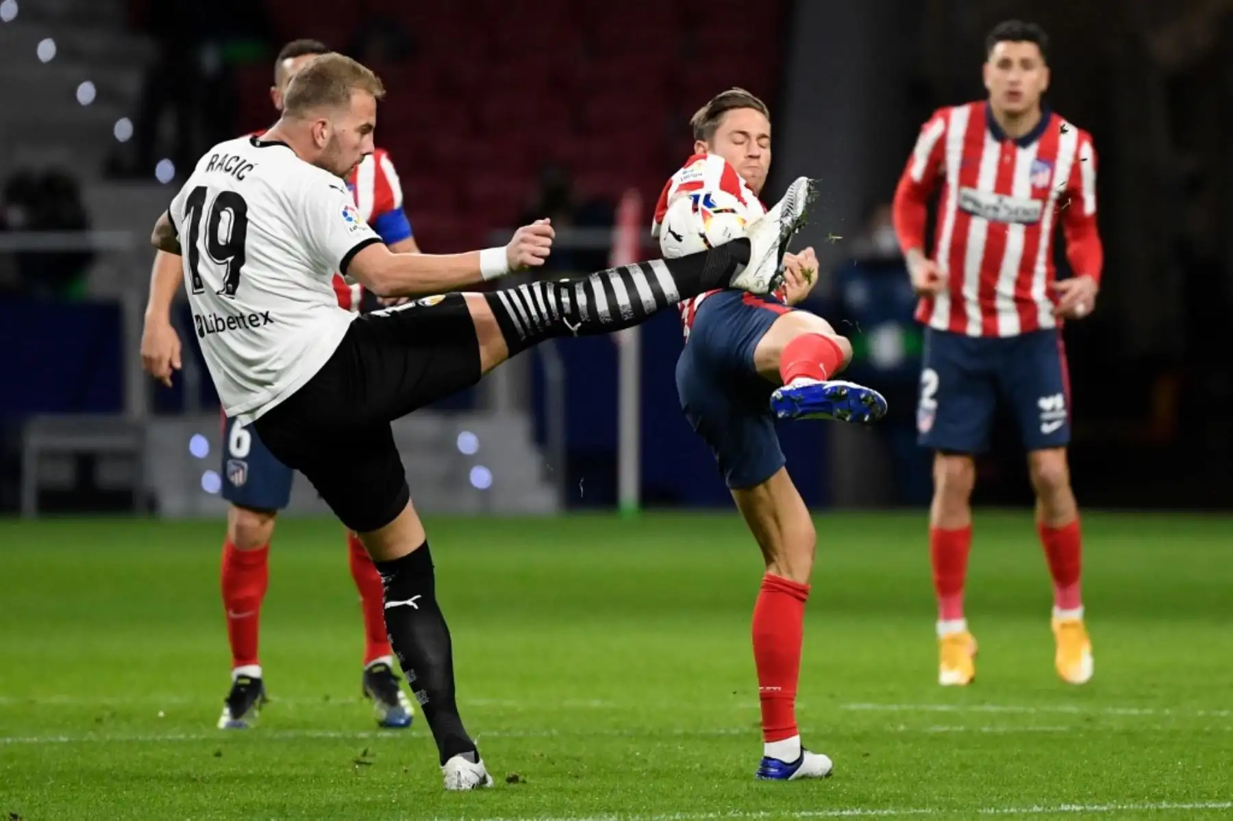 El centrocampista serbio del Valencia Uros Racic (L) compite con el centrocampista español del Atlético de Madrid Marcos Llorente durante el partido de fútbol de la liga española entre el Club Atlético de Madrid y el Valencia CF en el estadio Wanda Metropolitano de Madrid. Foto: AFP