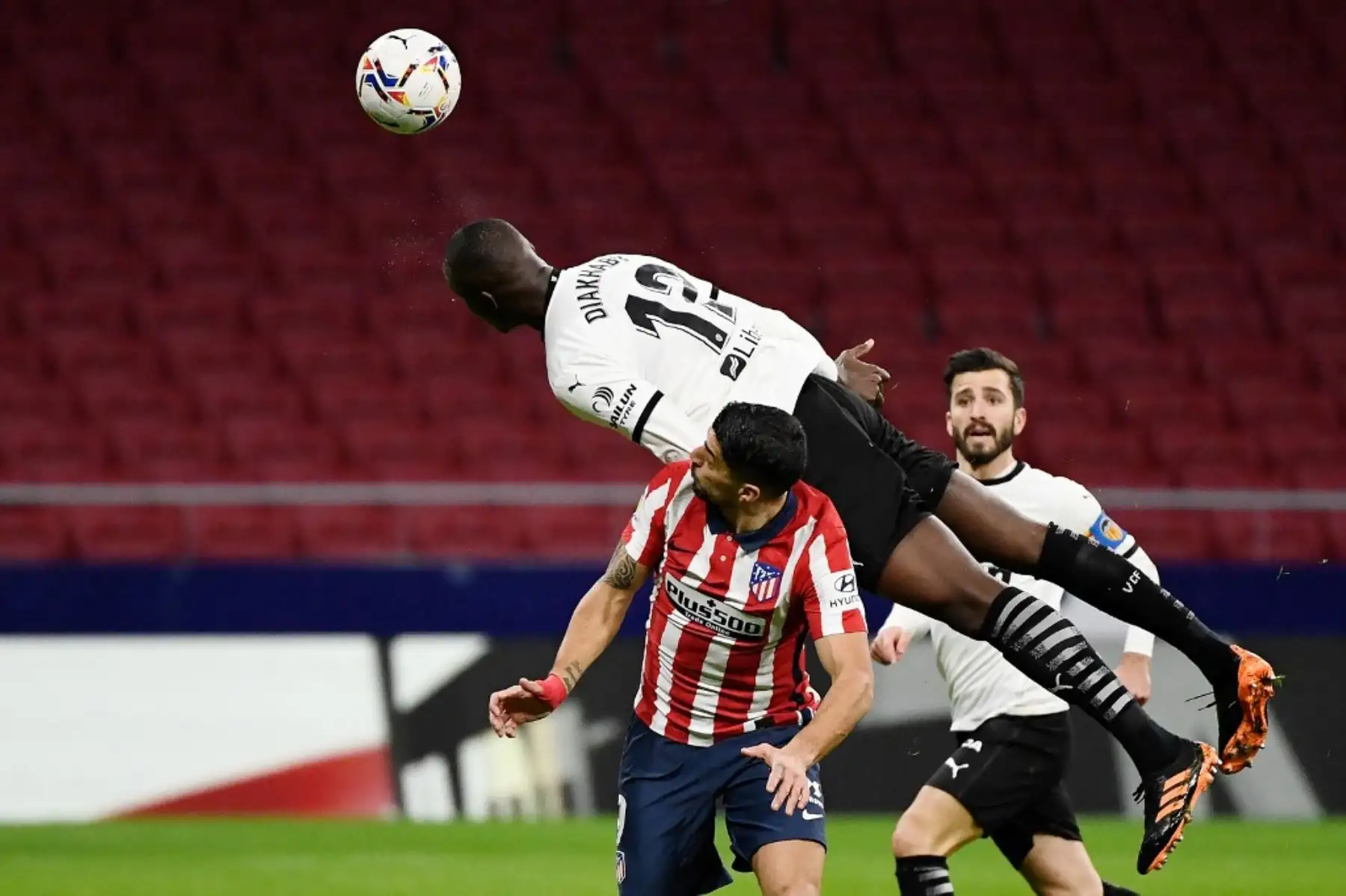 El defensor francés del Valencia Mouctar Diakhaby cabecea el balón durante el partido de fútbol de la liga española entre el Club Atlético de Madrid y el Valencia CF en el estadio Wanda Metropolitano de Madrid. Foto: AFP