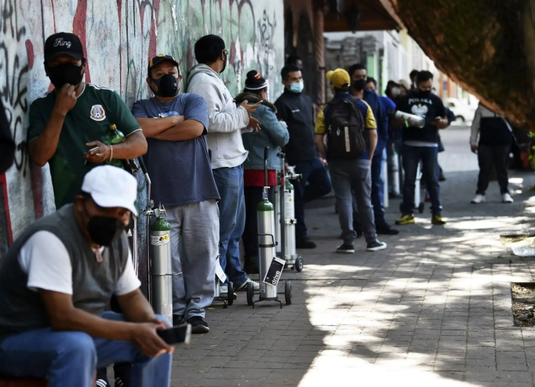 Personas hacen fila para rellenar los tanques de oxígeno en la Compañía Infra Medica en la Ciudad de México. Foto: AFP