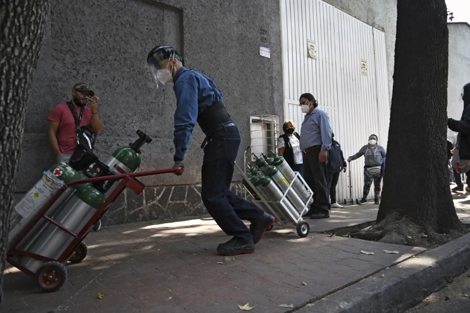 Personas hacen fila para rellenar los tanques de oxígeno en la Compañía Infra Medica en la Ciudad de México. Foto: AFP