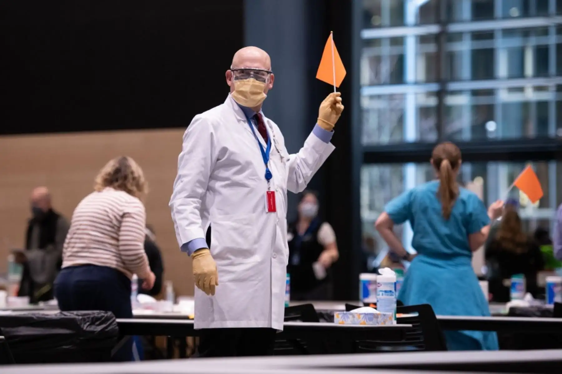 El director clínico John Corman MD en Virginia Mason ondea una bandera que indica que necesita otro paciente para vacunar con la vacuna Pfizer Covid-19 en el Amazon Meeting Center en el centro de Seattle, Washington. Foto: AFP