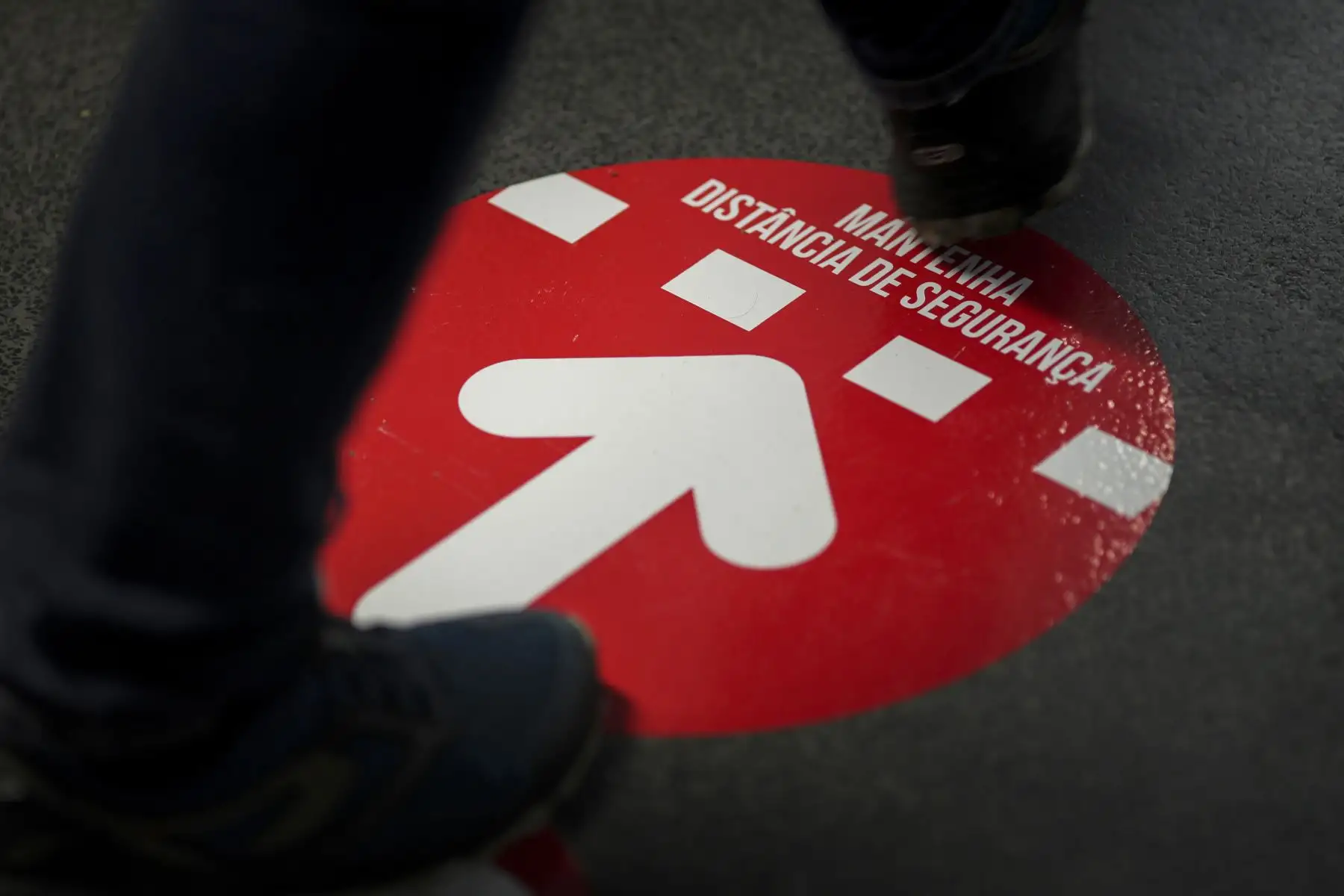 Un votante camina sobre un cartel de distanciamiento social durante las elecciones presidenciales portuguesas en un colegio electoral en el Parque das Nacoes en Lisboa, Portugal está votando a pesar del bloqueo pandémico del país. Foto: AFP