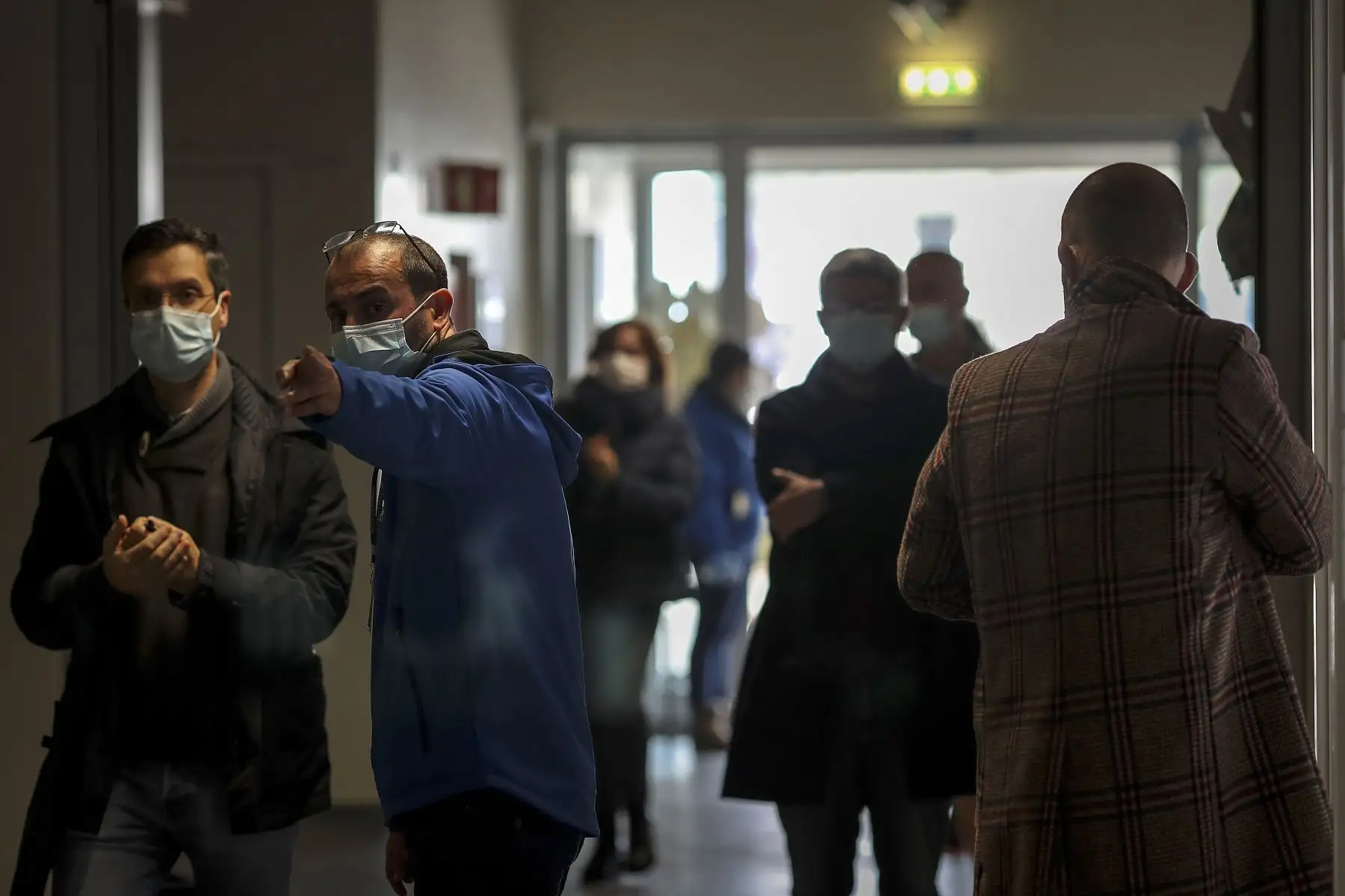 Un trabajador electoral con una máscara facial dirige a un votante a su centro de votación en las elecciones presidenciales portuguesas en una escuela en el Parque das Nações en Lisboa, Los portugueses votan hoy para las elecciones presidenciales.