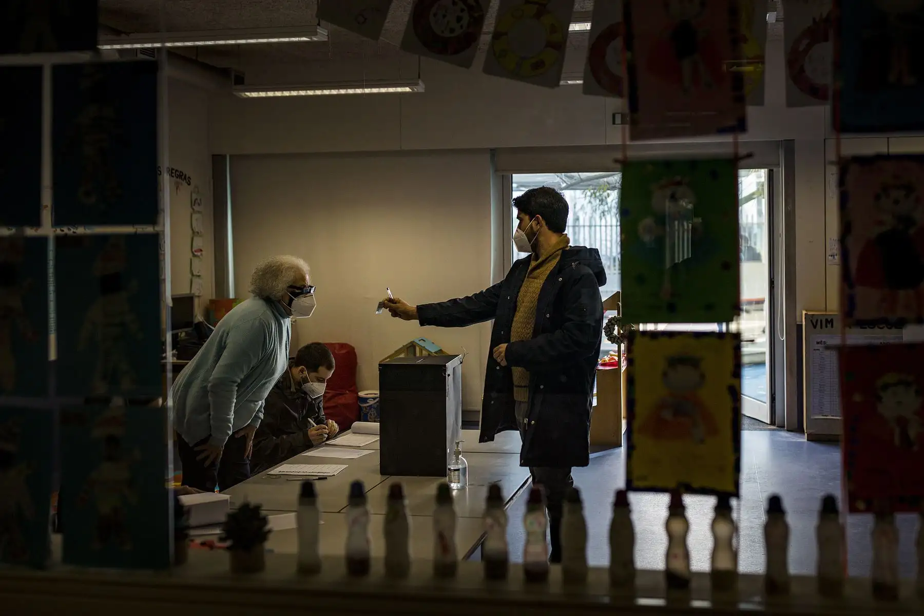 Un hombre muestra su tarjeta de identificación a los trabajadores electorales antes de votar para las elecciones presidenciales portuguesas en una escuela que se utiliza como centro de votación en el Parque das Nacoes en Lisboa, Portugal está votando a pesar del bloqueo pandémico del país. 
Foto: AFP