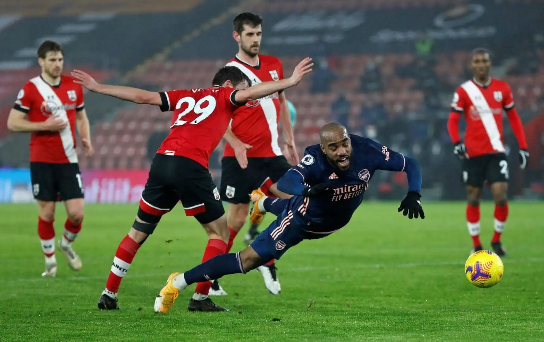 El defensa inglés de Southampton, Jake Vokins, compite con el delantero francés del Arsenal, Alexandre Lacazette, durante el partido de fútbol de la Premier League inglesa entre Southampton y Arsenal en el St Mary