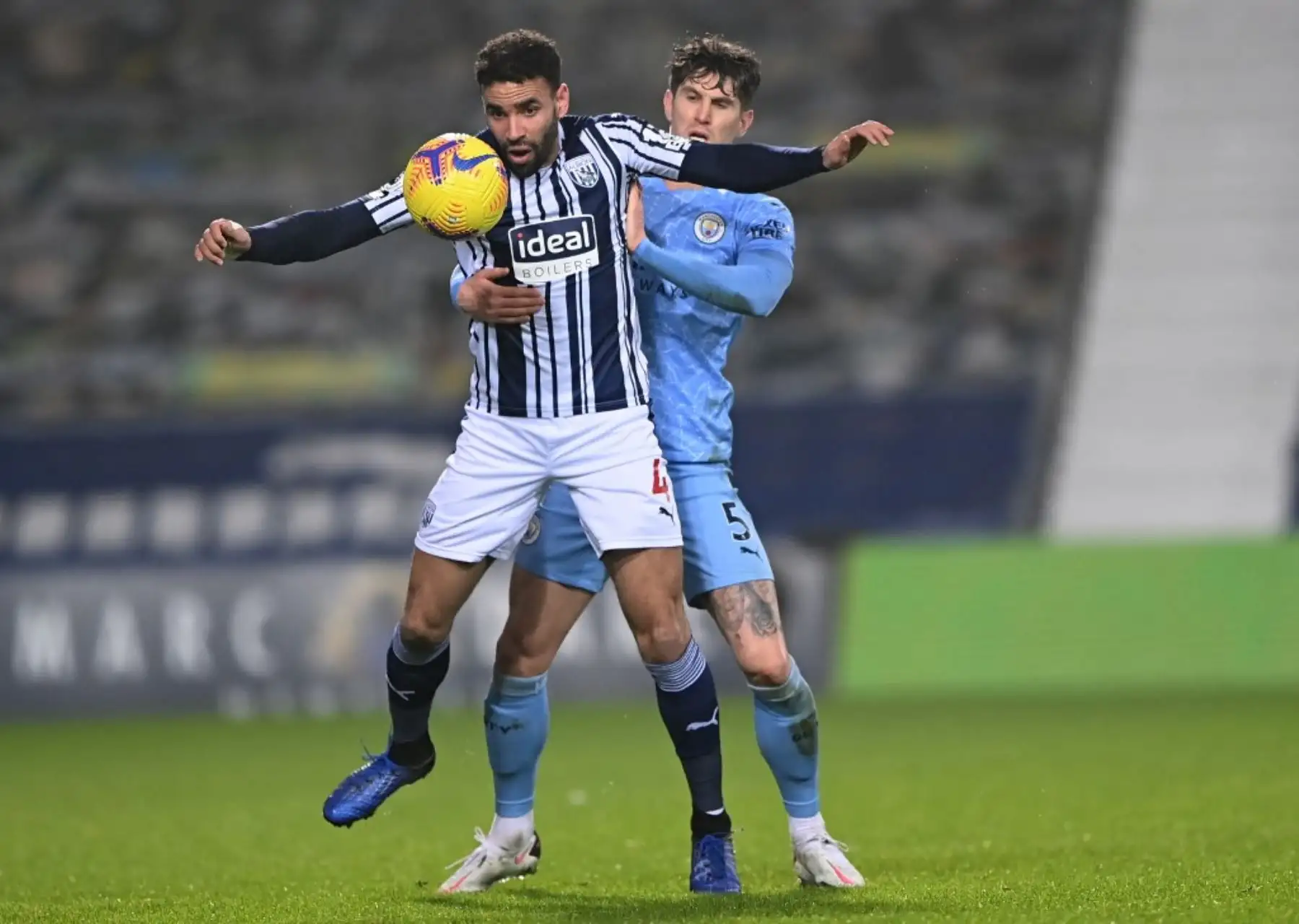 El delantero galés de origen inglés del West Bromwich Albion Hal Robson-Kanu (izq.) Compite con el defensor inglés del Manchester City John Stones durante el partido de fútbol de la Premier League inglesa entre el West Bromwich Albion y el Manchester City en el estadio The Hawthorns en West Bromwich, en el centro de Inglaterra. Foto: AFP