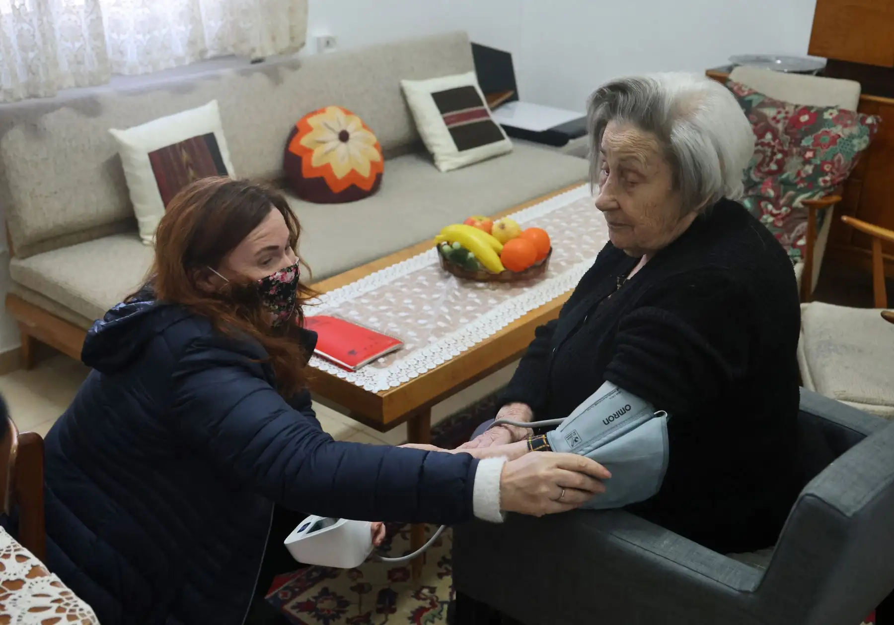 La sobreviviente del Holocausto, Miriam Linia, recibe apoyo médico de un voluntario en las instalaciones de la fundación Yad Ezer La-Haver de Israel, que apoya a los sobrevivientes del Holocausto proporcionándoles alimentos, así como asistencia médica y psicológica, en la ciudad portuaria norteña de Haifa en enero. Foto: AFP