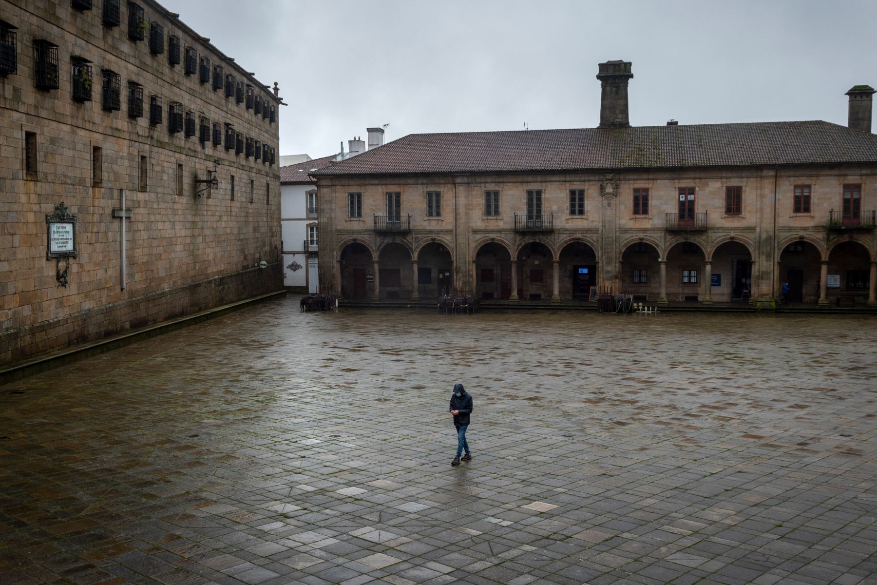 Una persona camina por la vacía Plaza Quintana, junto a la Catedral, en el centro de Santiago de Compostela, noroeste de España, donde se han registrado hasta el momento más de 55.000 muertes de casi 2,5 millones de casos de Covid-19. Foto: AFP
