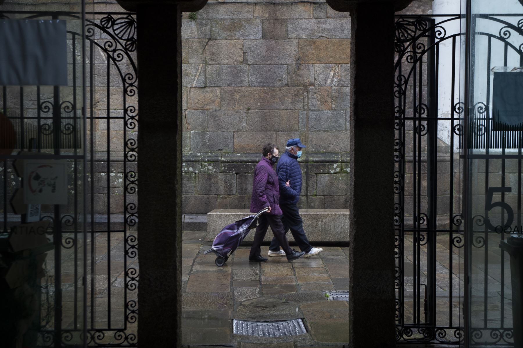 Una pareja con mascarillas va al mercado de abastos de Santiago de Compostela, noroeste de España, donde se han registrado hasta el momento más de 55.000 muertes de casi 2,5 millones de casos de Covid-19. Foto: AFP