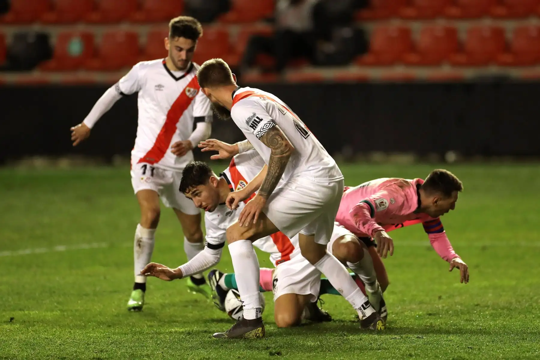 El delantero argentino del FC Barcelona, Leo Messi (d), cae ante los jugadores del Rayo Vallecano, Santiago Comesaña y el argentino Esteban Saveljich, durante el encuentro correspondiente a los octavos de final de la Copa del Rey que disputan hoy Miércoles en el estadio de Vallecas, en Madrid. Foto: EFE/Kiko Huesca