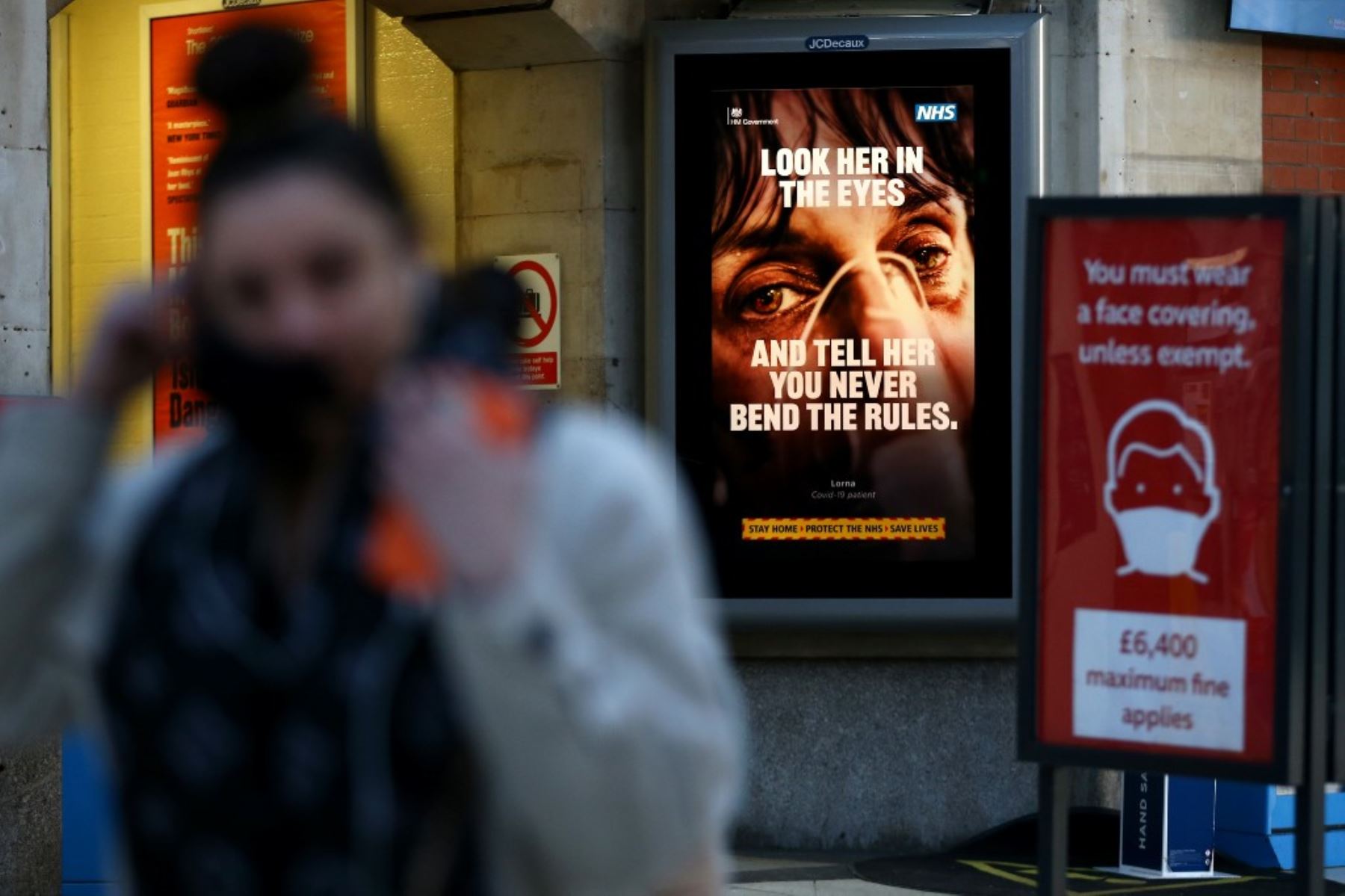 Un peatón pasa junto a un cartel informativo de Covid-19 en la estación de tren de Victoria en el centro de Londres. Foto: AFP
