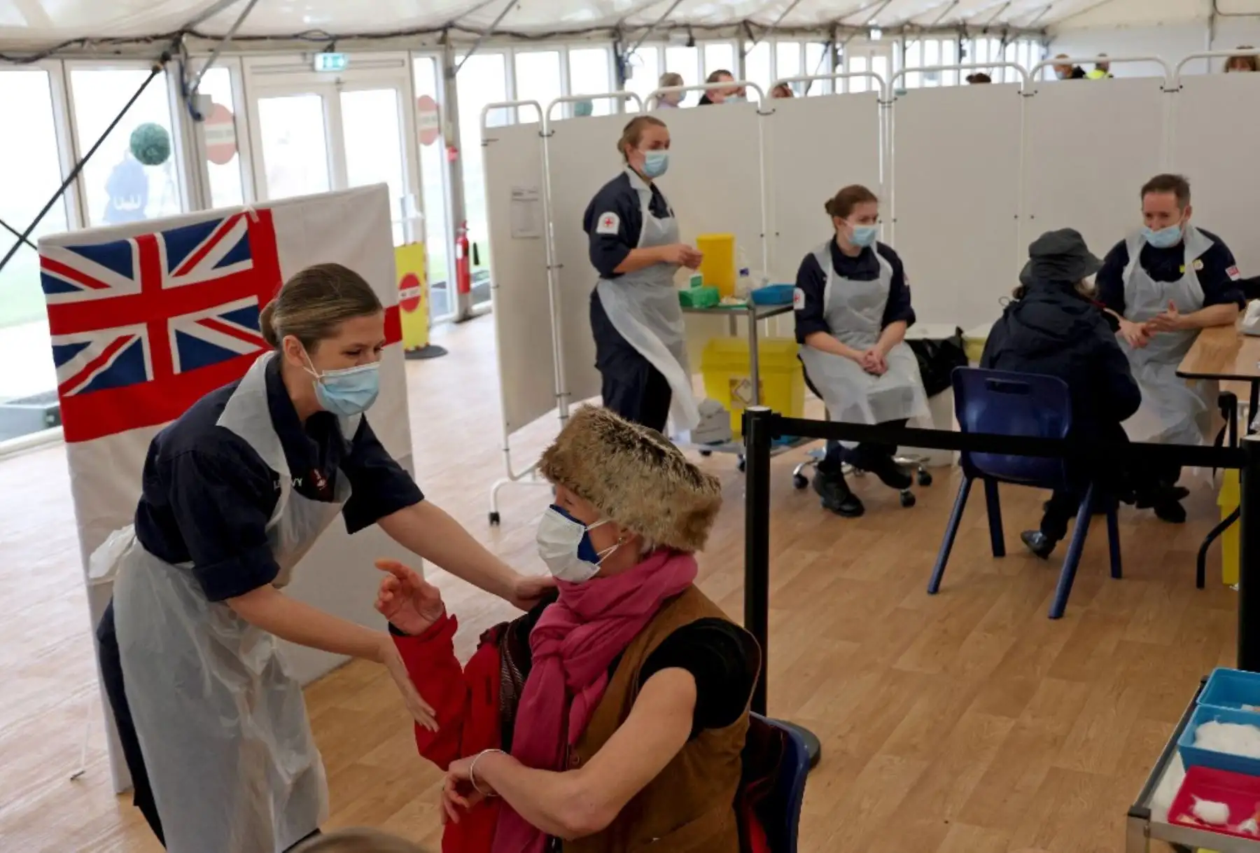 Un paciente recibe una inyección de la vacuna Covid-19 de Oxford / AstraZeneca por médicos de la Royal Navy en un centro de vacunación establecido en el hipódromo de Bath en Bath, suroeste de Inglaterra. Foto: AFP