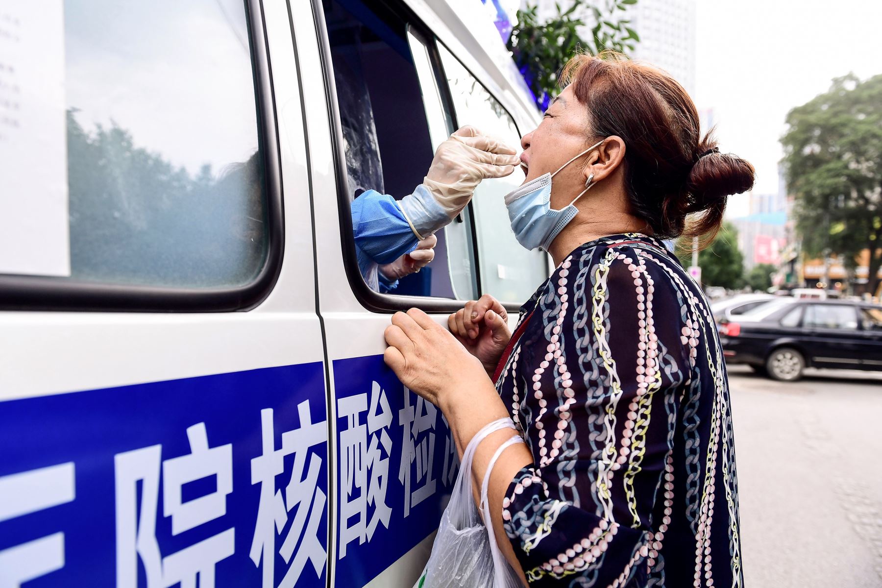 La Comisión Nacional de Sanidad de China anunció la detección de 54 nuevos contagios del coronavirus SARS-CoV-2, de los que 41 son infecciones locales. Un trabajador de la salud realiza una prueba de coronavirus COVID-19 en un residente en un vehículo de prueba en Shenyang, en la provincia nororiental de Liaoning. Foto: AFP