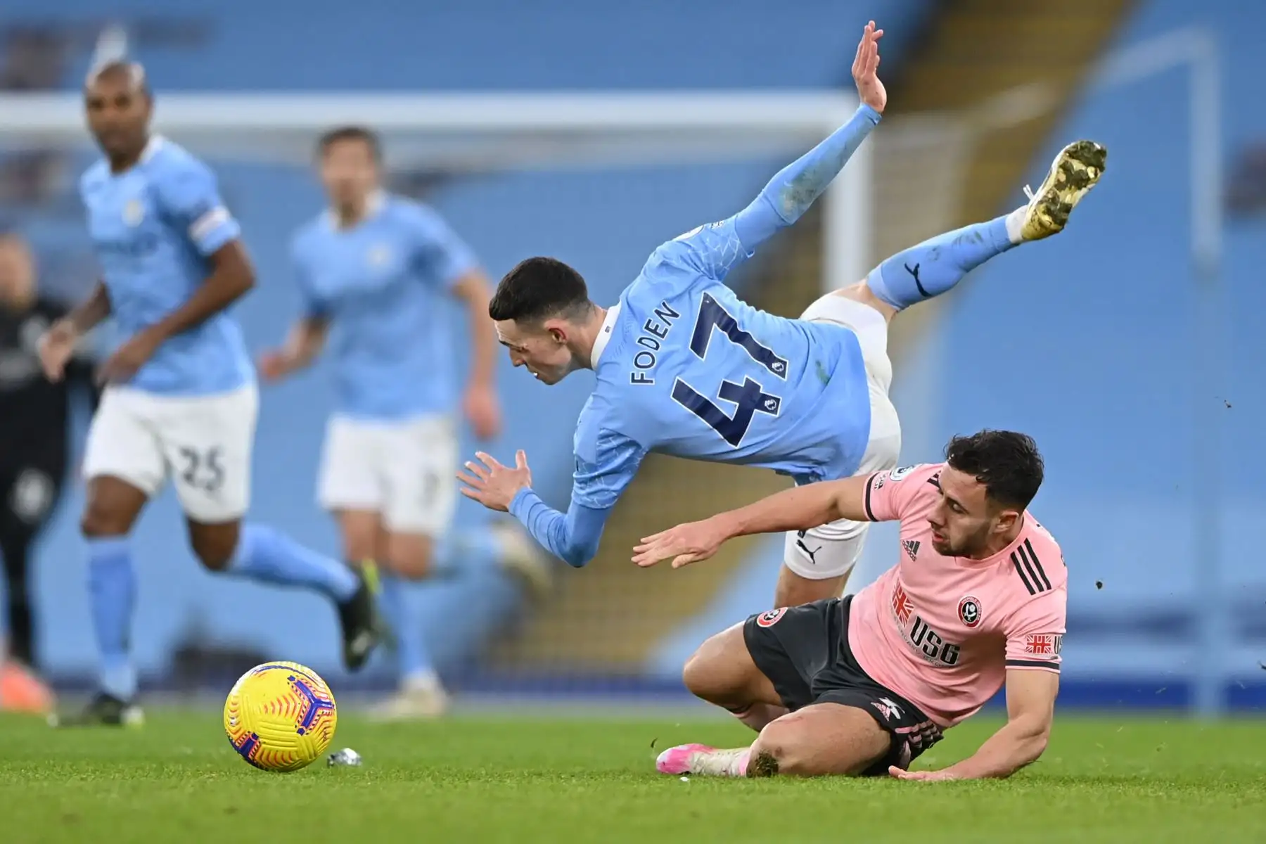 El defensa inglés del Sheffield United George Baldock comete una falta al mediocampista inglés del Manchester City Phil Foden para ganar una tarjeta amarilla durante el partido de fútbol de la Premier League inglesa entre el Manchester City y el Sheffield United, noroeste de Inglaterra. 
Foto: AFP