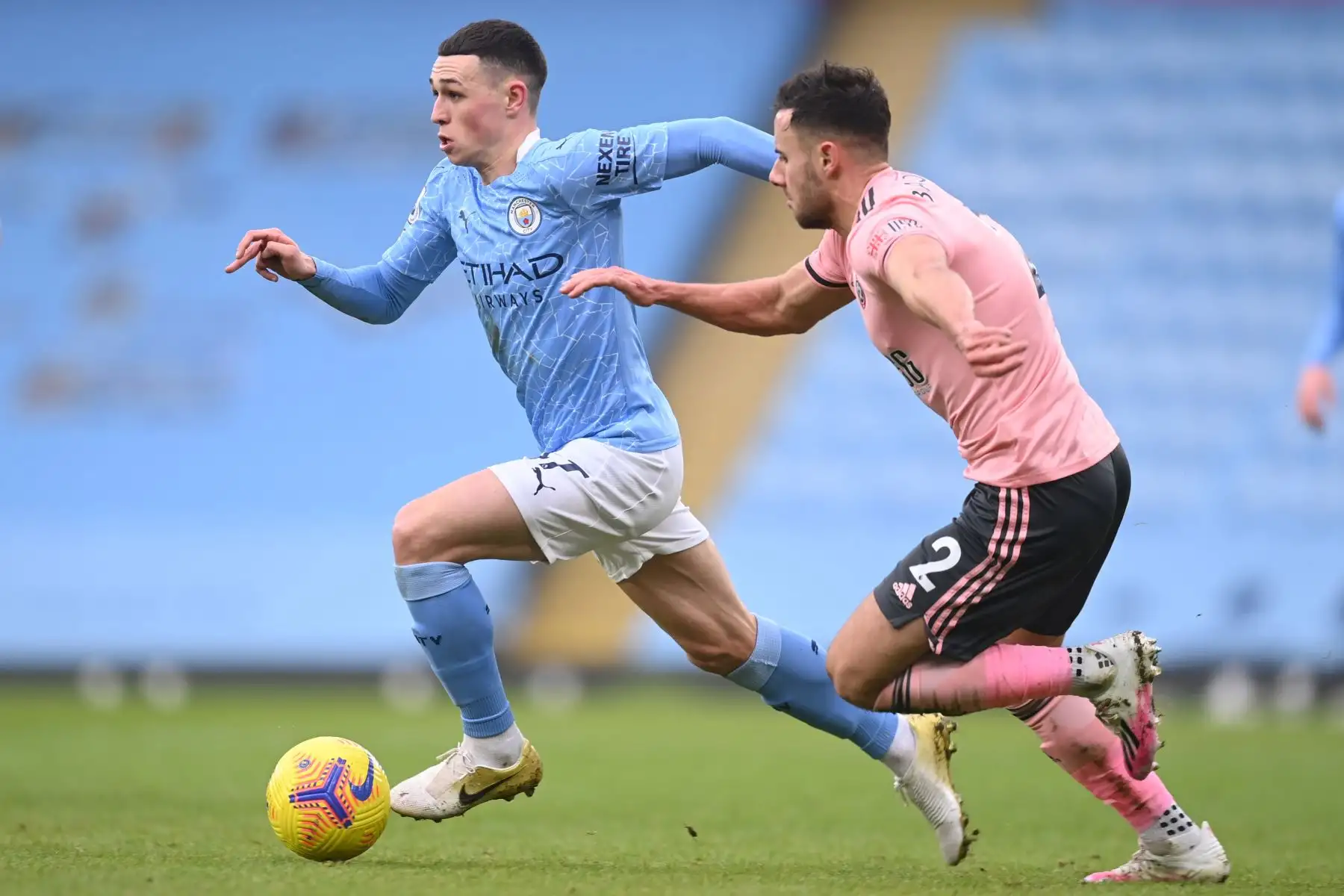 El centrocampista inglés del Manchester City Phil Foden huye del defensor inglés del Sheffield United, George Baldock  durante el partido de fútbol de la Premier League inglesa entre el Manchester City y el Sheffield United.
Foto: AFP