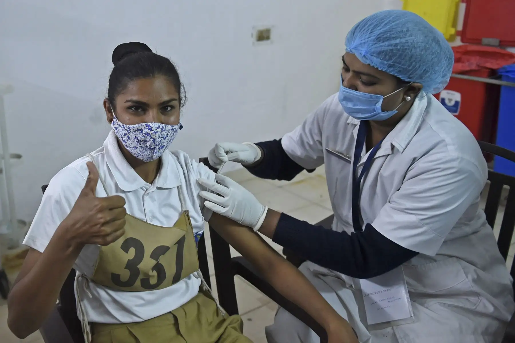 Un trabajador de la salud vacuna al personal de Lok Rakshak Dal (LRD) de la policía de Gujarat con una vacuna contra el coronavirus en un hospital civil en Ahmedabad.
Foto: AFP