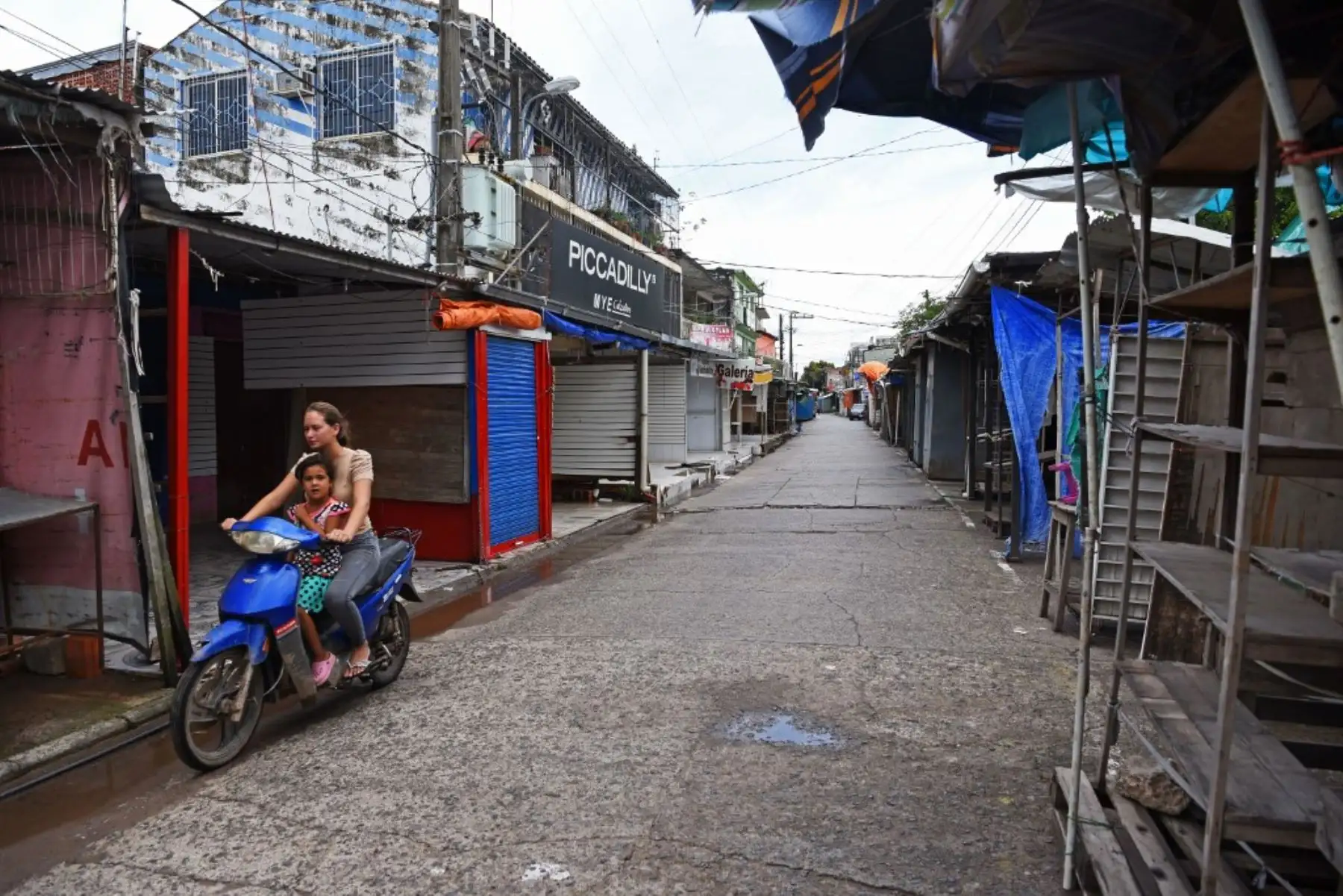 Una mujer pasa por una calle con tiendas cerradas en Nanawa, Paraguay. Las medidas del gobierno sobre el covid-19 convirtieron a Nanawa en un pueblo fantasma, ya que los dueños de las tiendas se vieron obligados a cerrar sus tiendas debido al estricto control ejercido por agentes fronterizos sobre el paso de personas. Foto: AFP